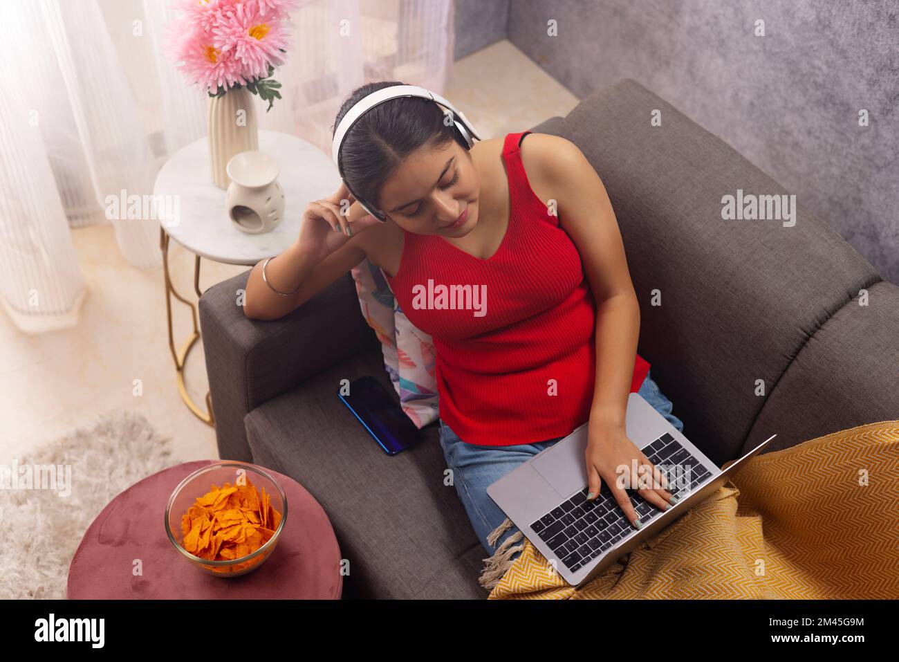 Draufsicht eines Teenagers, das ein Notebook benutzt und zu Hause Musik hört Stockfoto