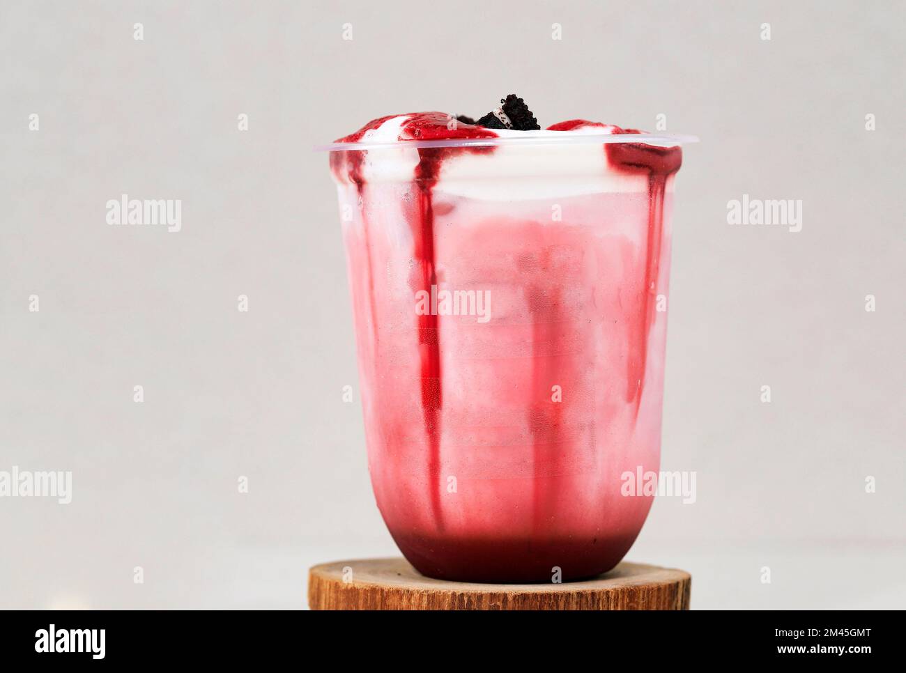 Red Velvet Trinken Sie Milch in einem Plastikbecher. Mit Keksen Crumb Topping. Concept Fresh Drink Smoothies zum Mitnehmen Stockfoto