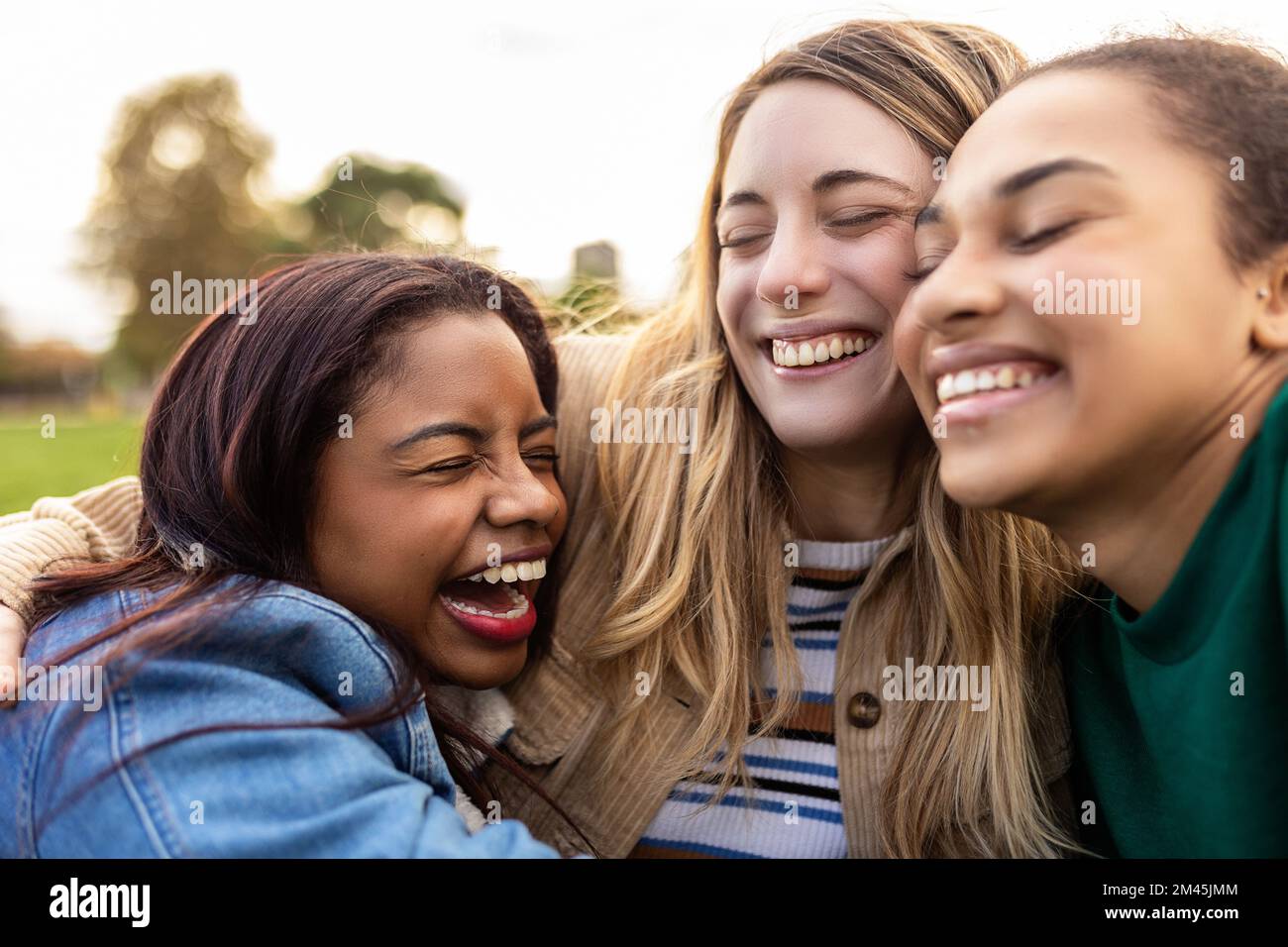 Authentische, multiethnische, beste Frauenfreunde, die sich im Freien umarmen Stockfoto