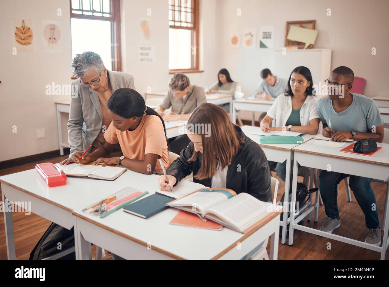 Schule, Schüler und Klassenzimmer mit Hilfe von Lehrern, Antworten und Erklärungen während des Unterrichts mit der jungen Gruppe. Bildung, Studium und Altenunterricht Stockfoto