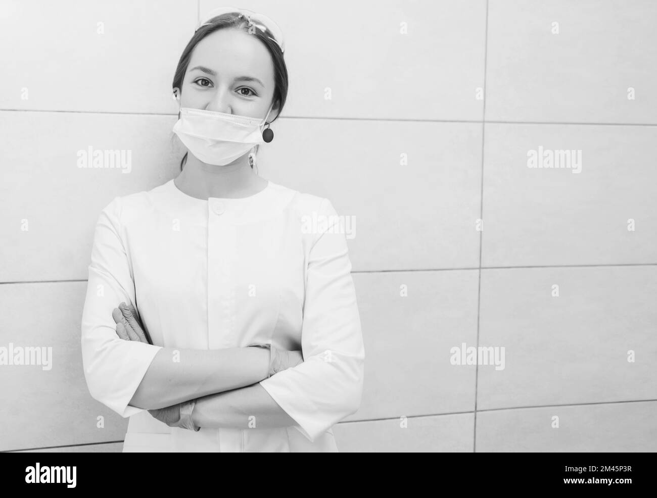 Junge Zahnärztin in weißer Jacke und Handschuhen am Arbeitsplatz. Platz für Text Stockfoto