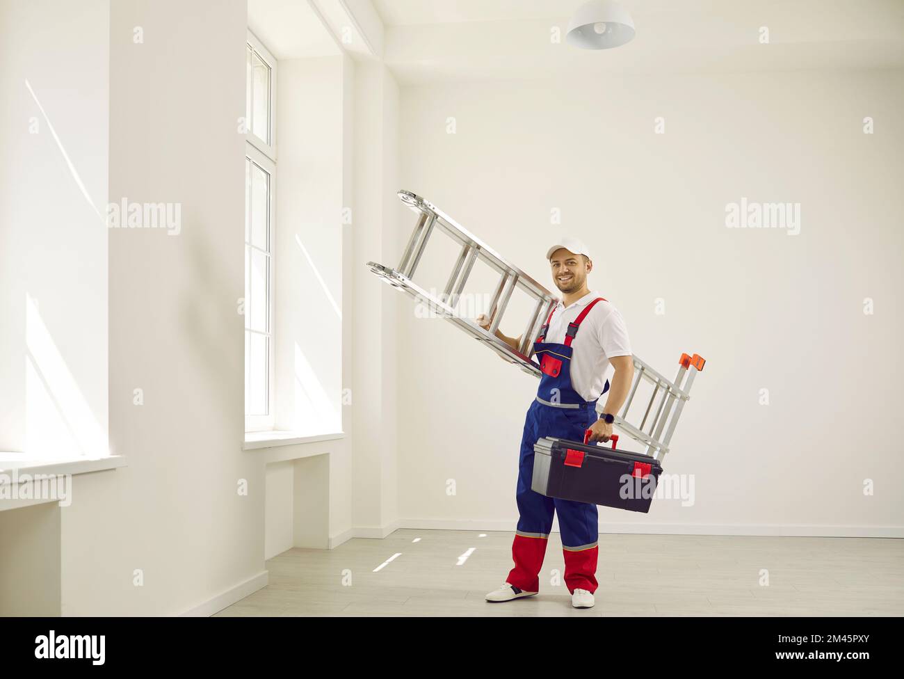 Der Techniker kam mit einer hoch klappbaren Leiter und einem Werkzeugkasten zur Arbeit. Stockfoto