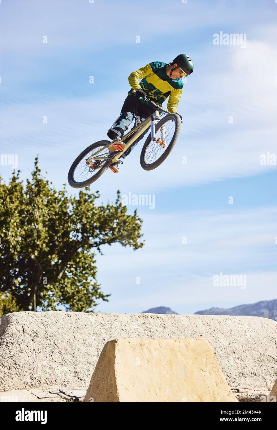 Mann, Radfahrer und Mountainbike-Touren in freier Natur, Tricks oder extremes Hügelspringen in der Natur. Professioneller männlicher Radfahrer in den Bergen mit Stockfoto