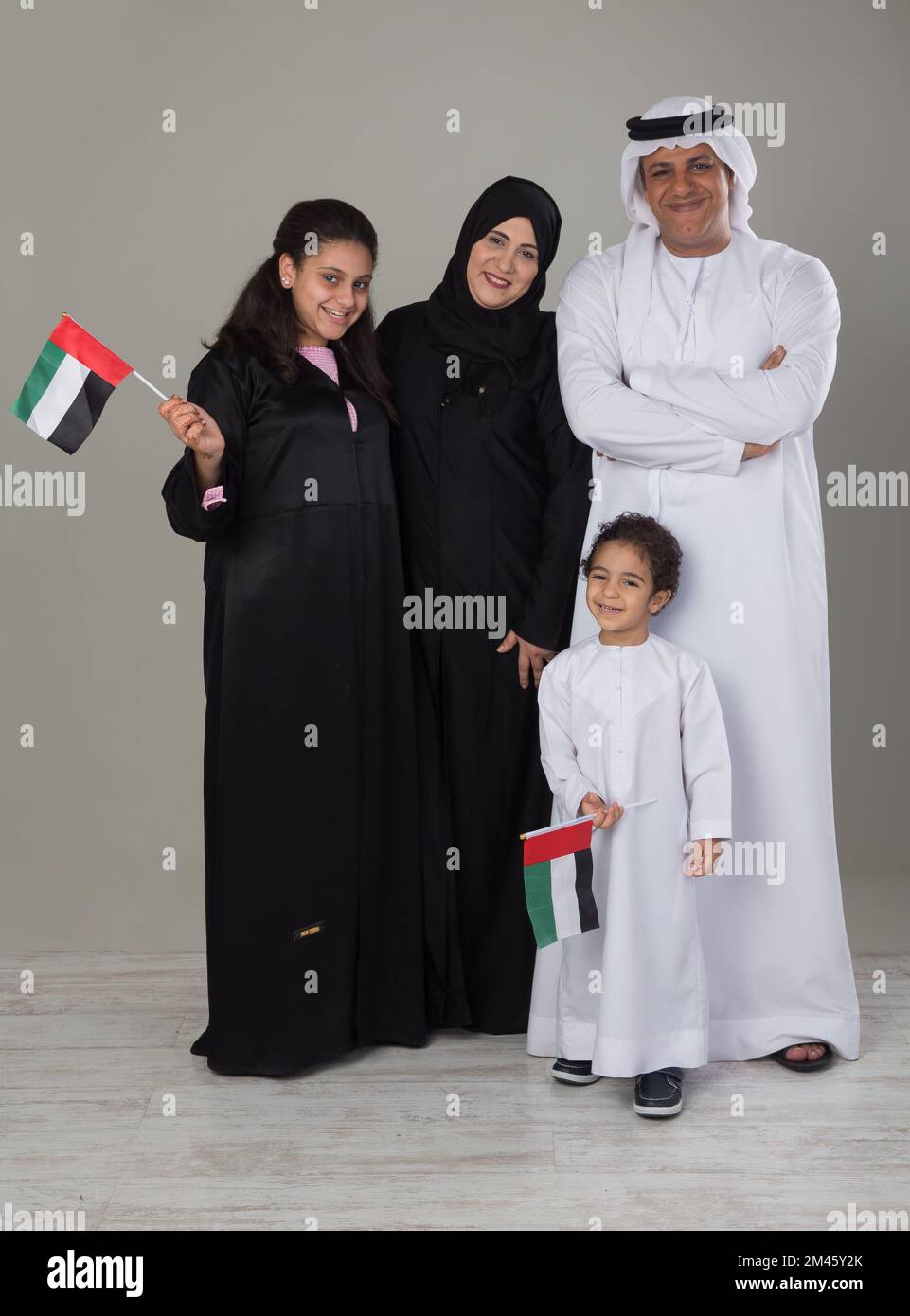 Eine arabische Familie mit zwei Kindern, die die Nationalflagge der Vereinigten Arabischen Emirate halten. Stockfoto