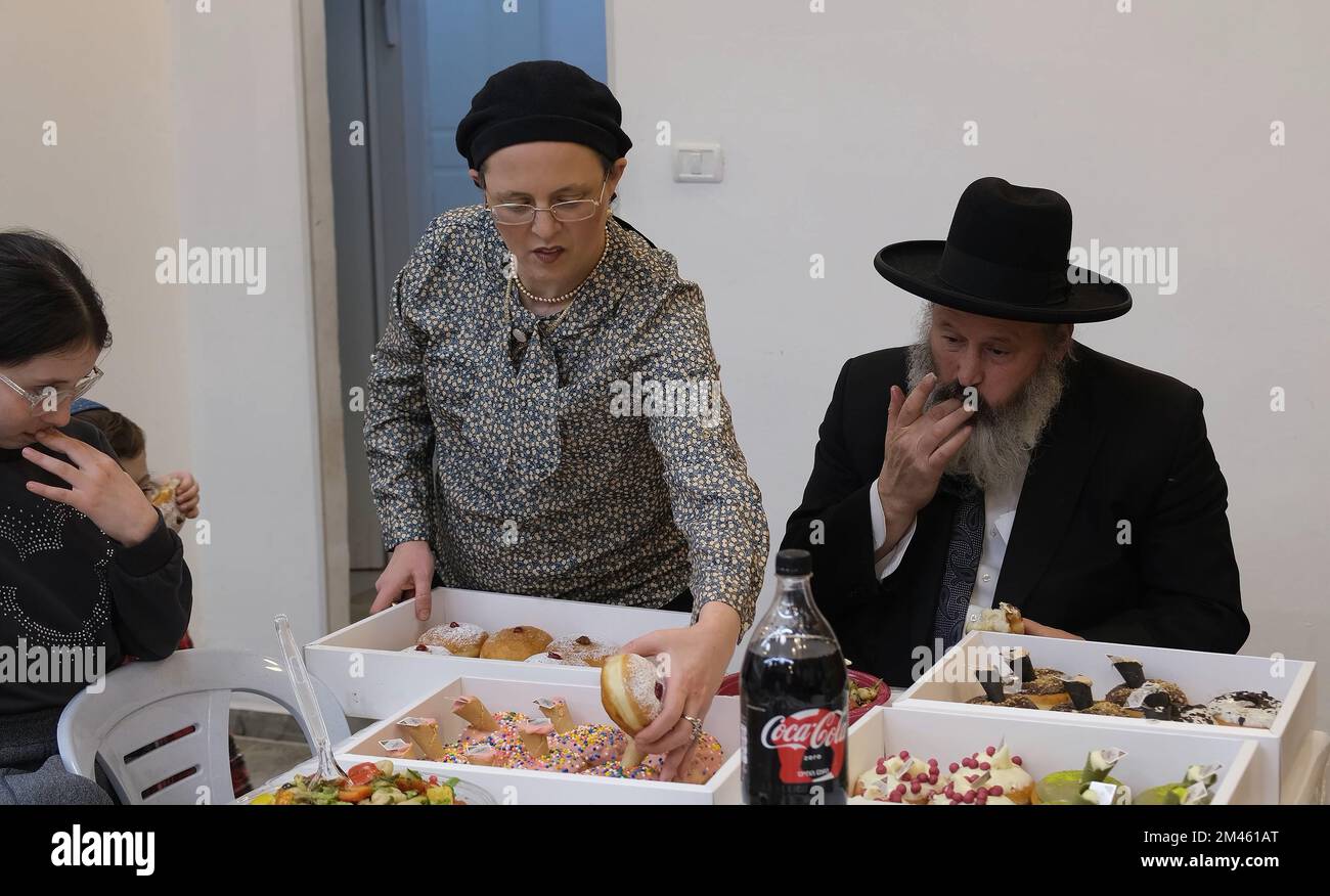 JERUSALEM, ISRAEL - DEZEMBER 18: Rabbi Yitzchak Goldstein, Leiter der Diaspora Yeshiva, isst am 18. Dezember 2022 in Jerusalem, Israel, während Hanukkah am ersten Abend des jüdischen Feiertags von Hanukka, manchmal auch als Lichterfest bezeichnet, einen traditionellen Sufganiyot-Donut. Juden auf der ganzen Welt feiern heute den ersten Tag von Hanukkah, dem achttägigen jüdischen Festival. Hanukka oder Chanukah gedenkt dem jüdischen Sieg 165 v. Chr. über die syrisch-griechische Unterdrückung unter der Führung von König Antiochus IV Kredit: Eddie Gerald/Alamy Live News Stockfoto