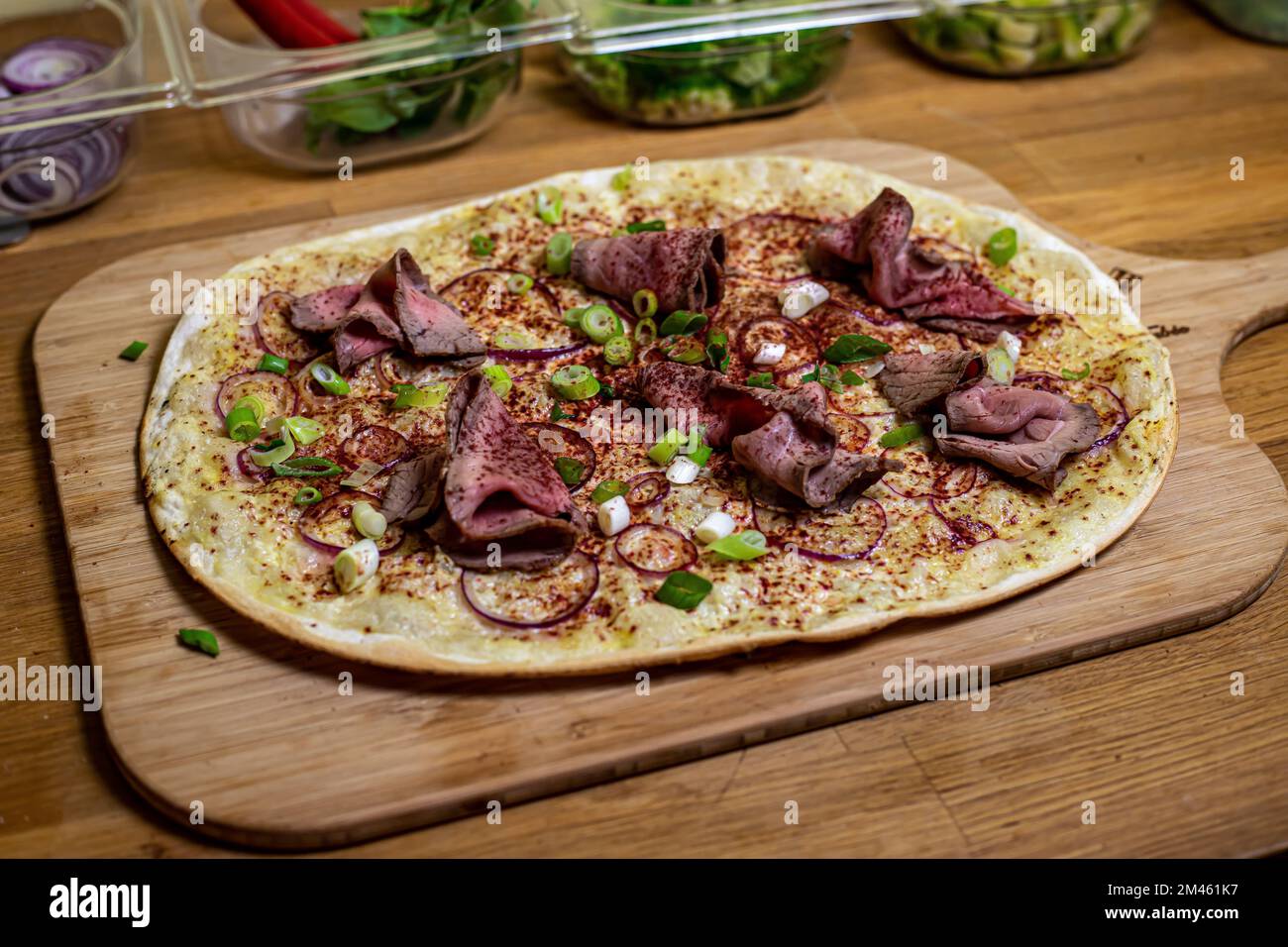 Eine Nahaufnahme einer französischen Pizza mit Tarte Flambe mit Roastbeef und lila Curry Stockfoto