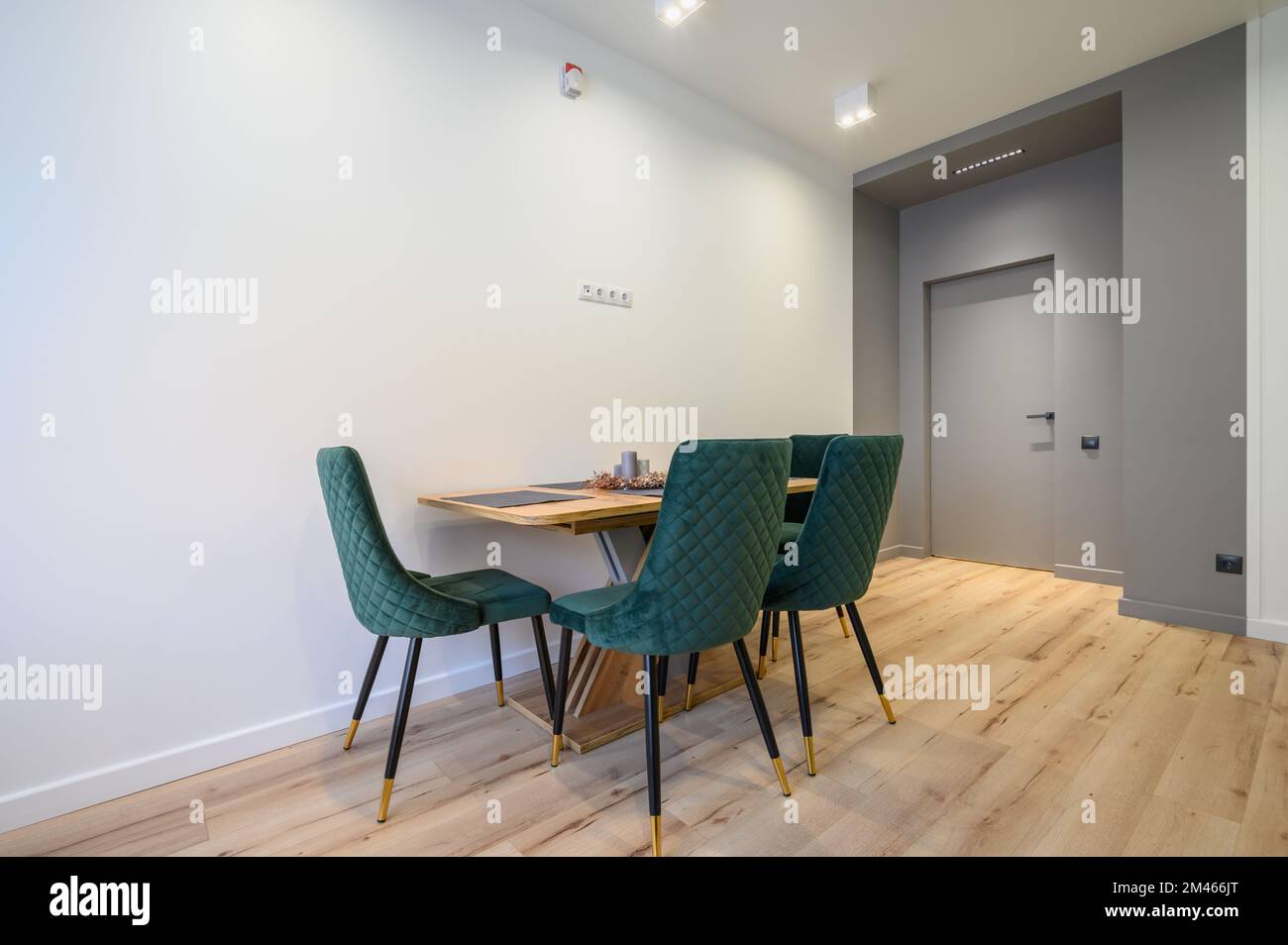 Esstisch mit grünen Stühlen in großer Küche mit Laminatboden Stockfoto