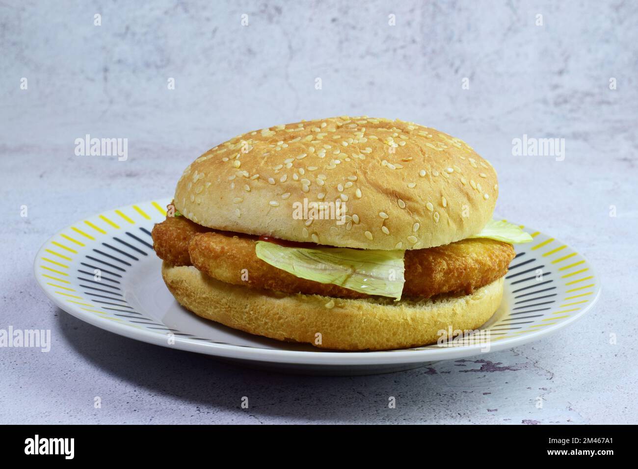 Ein köstliches Sandwich mit Chicken Nuggets, Salat und Sesambrötchen ...