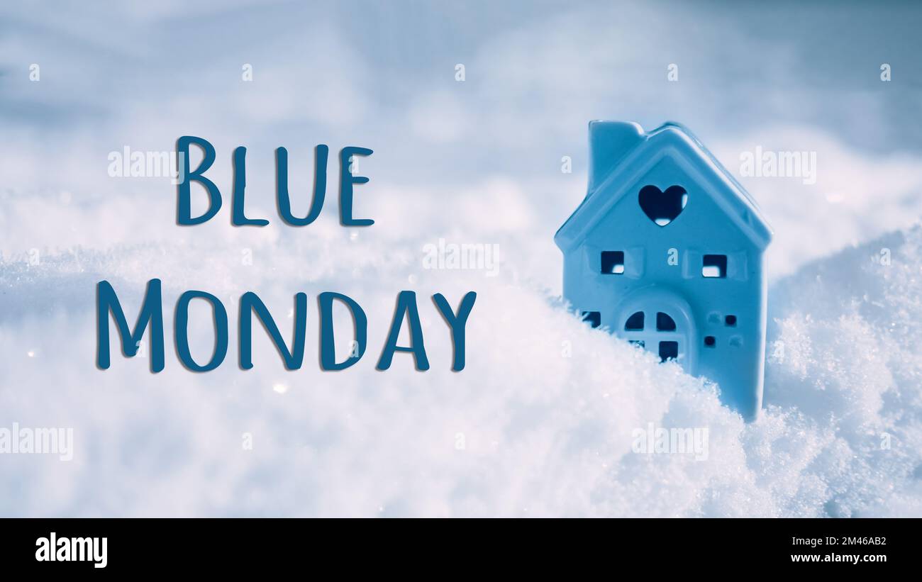 Blauer text am montag und kleines Haus auf kaltem Winterschneehintergrund. Blauer Montag im Januar, der deprimierendste Tag des Jahres. Traurig, einsam Stockfoto