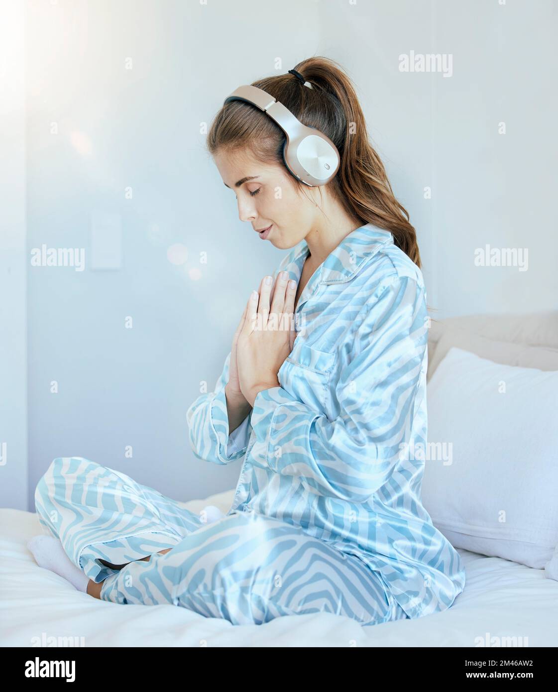 Frau, Musik-Kopfhörer oder namaste Meditation im Schlafzimmer, zu Hause oder Hotel für psychische Gesundheit, Stressmanagement oder Zen. Ruhe, Frieden oder Yoga Stockfoto