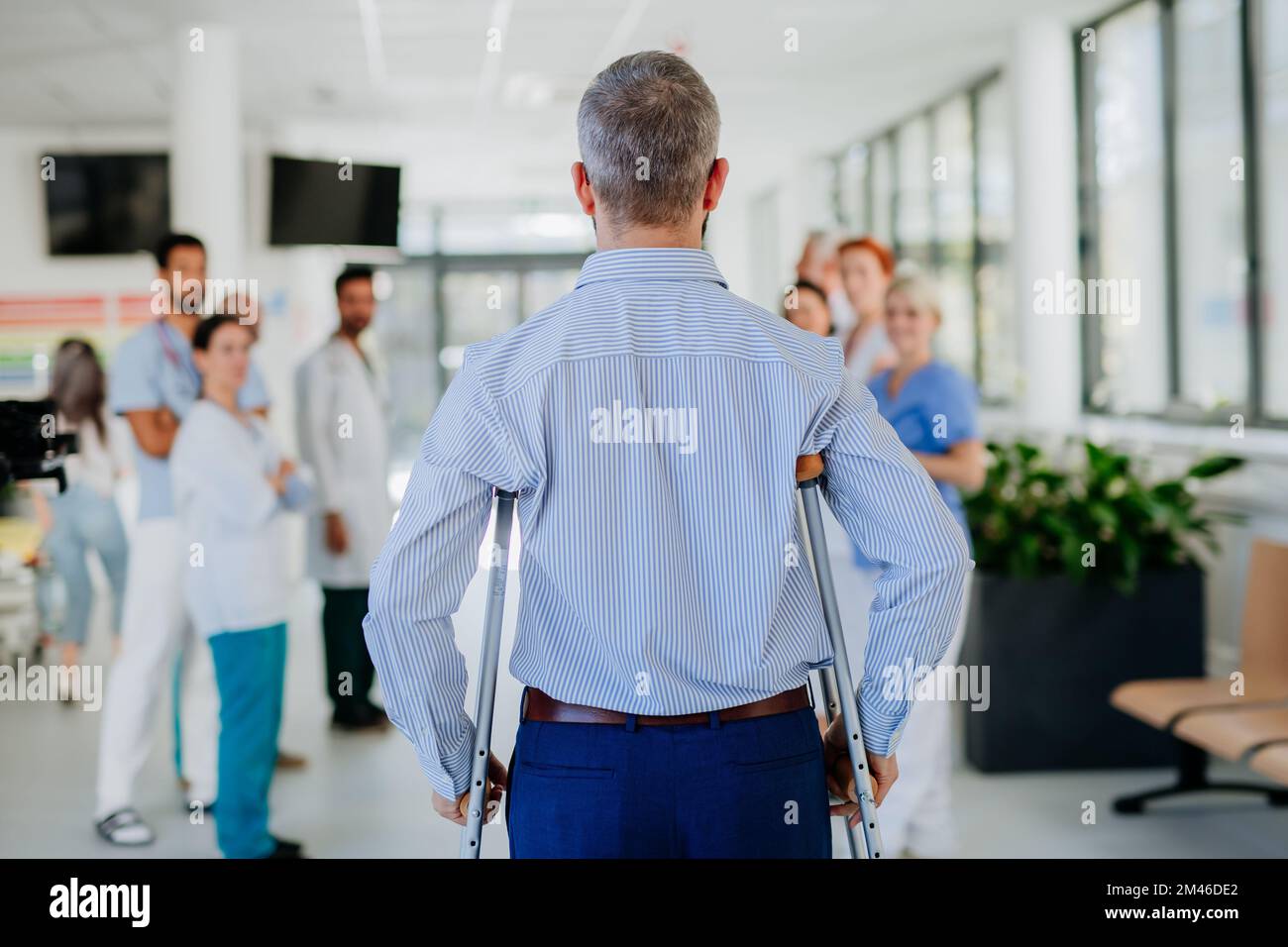Medizinisches Personal klatscht zu einem Patienten, der sich von einem schweren Unfall erholt hat. Stockfoto