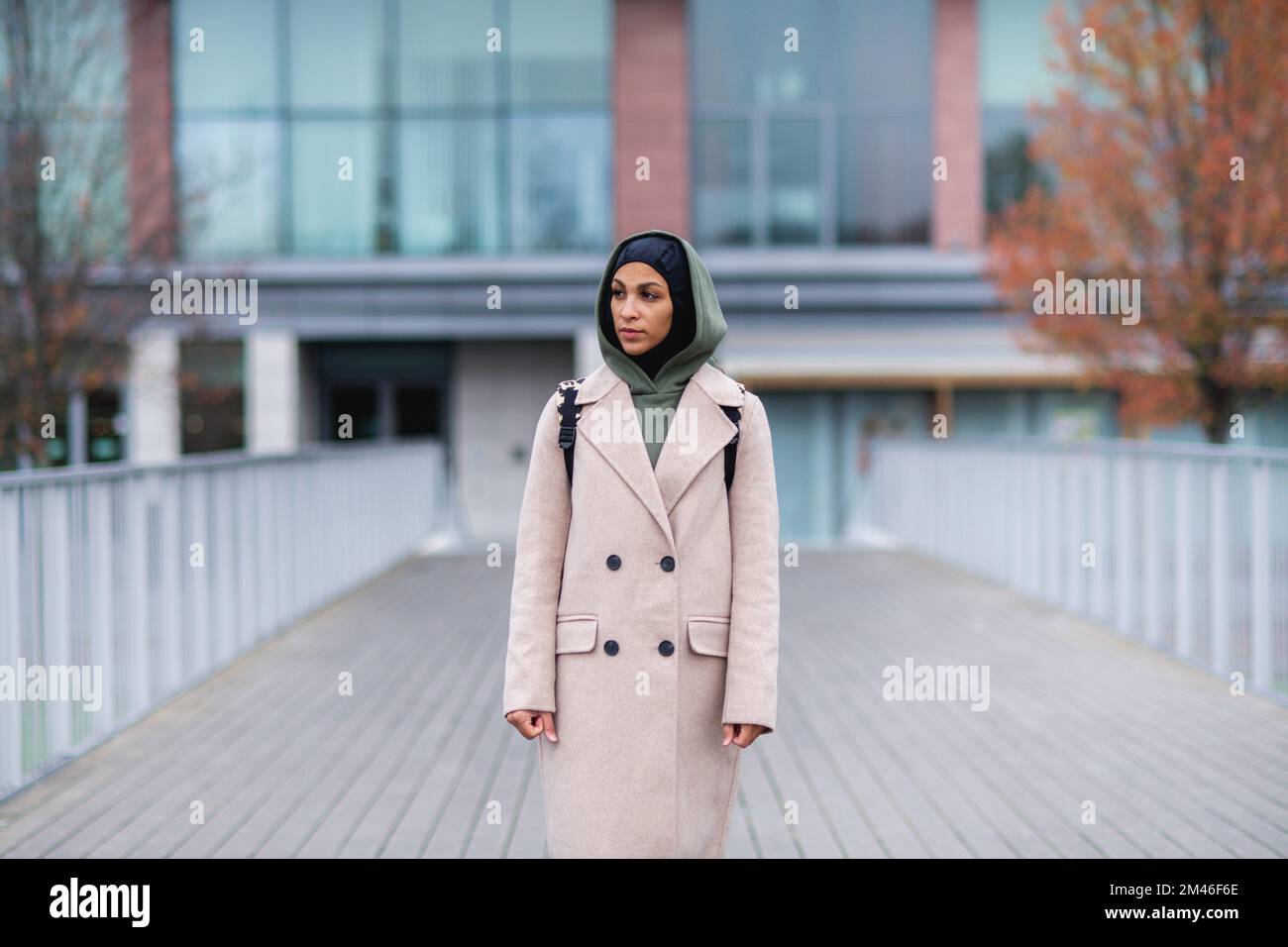 Junge, multirassische Frau, die auf einer Stadtbrücke steht. Stockfoto