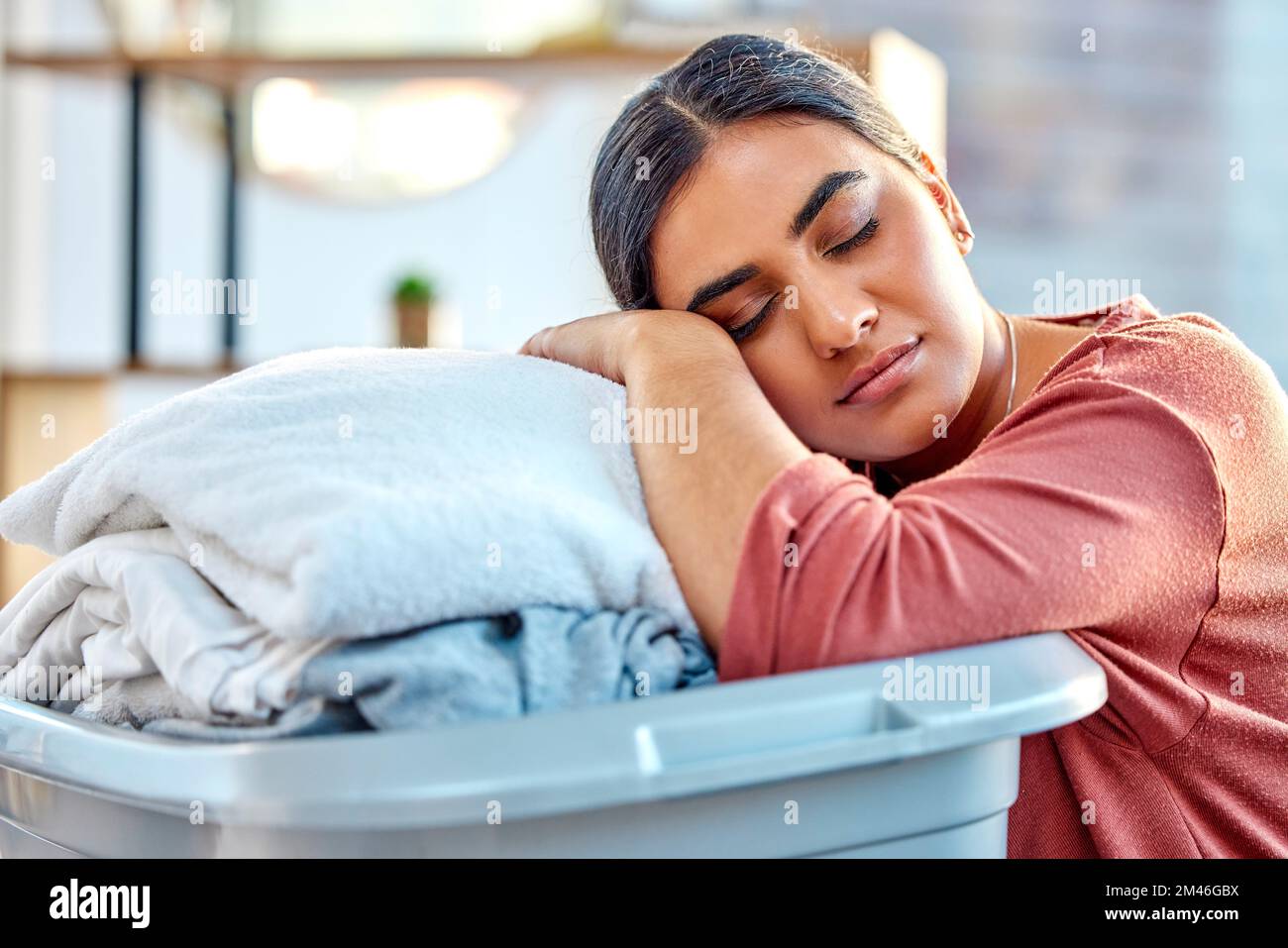 Frau, Wäschekorb und schlafen Sie müde, entspannen Sie sich oder ruhen Sie sich im Wohnzimmer aus, nachdem Sie geputzt, gewaschen und gepackt haben. Hausfrau, die sauberer ist und mit der schläft Stockfoto
