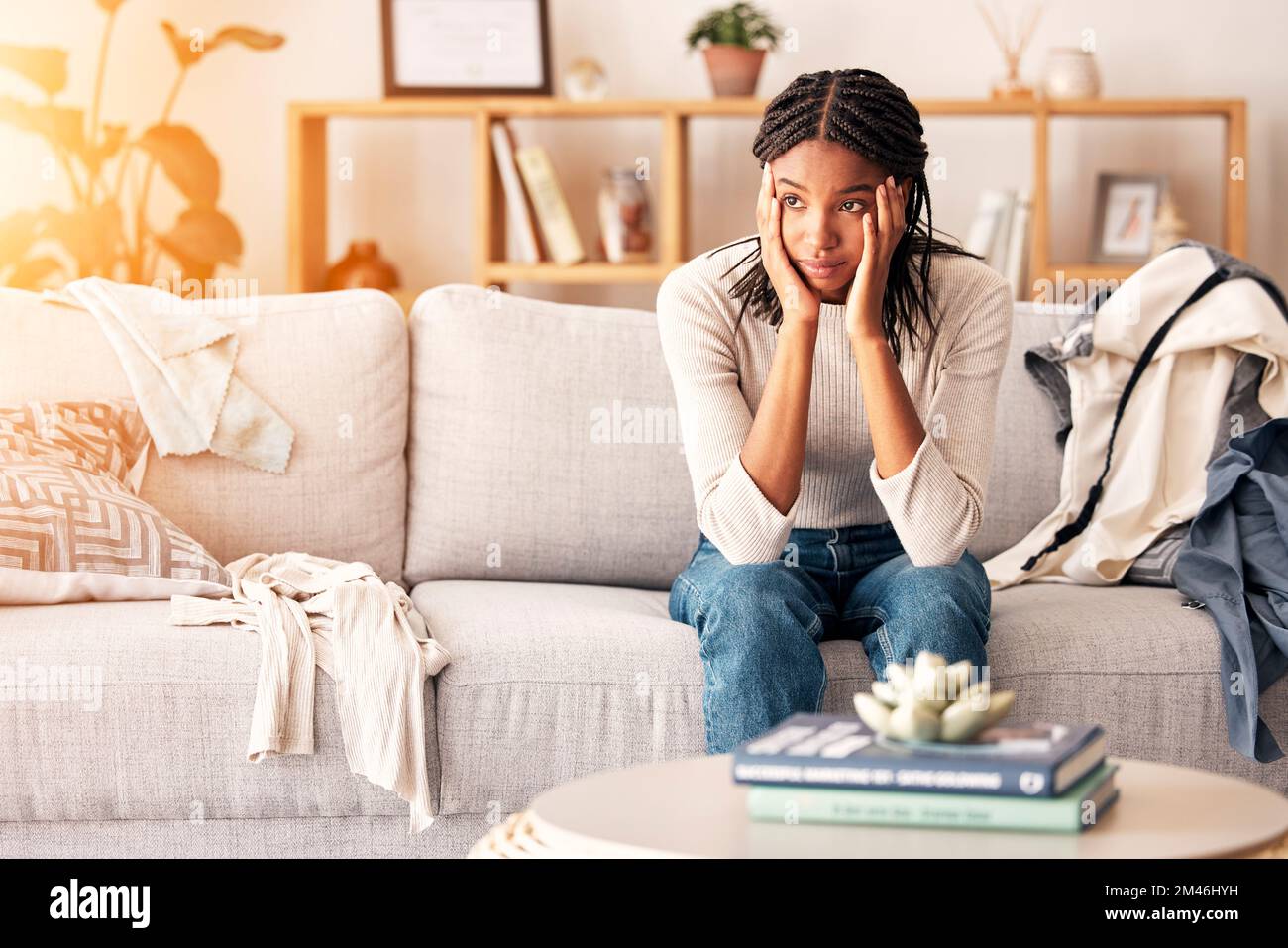 Traurige, denkende und schwarze Frau mit Depressionen auf dem Sofa zu Hause. Psychische Gesundheit, Angst und weibliche aus Nigeria auf der Couch erwägt Miete, Student Stockfoto