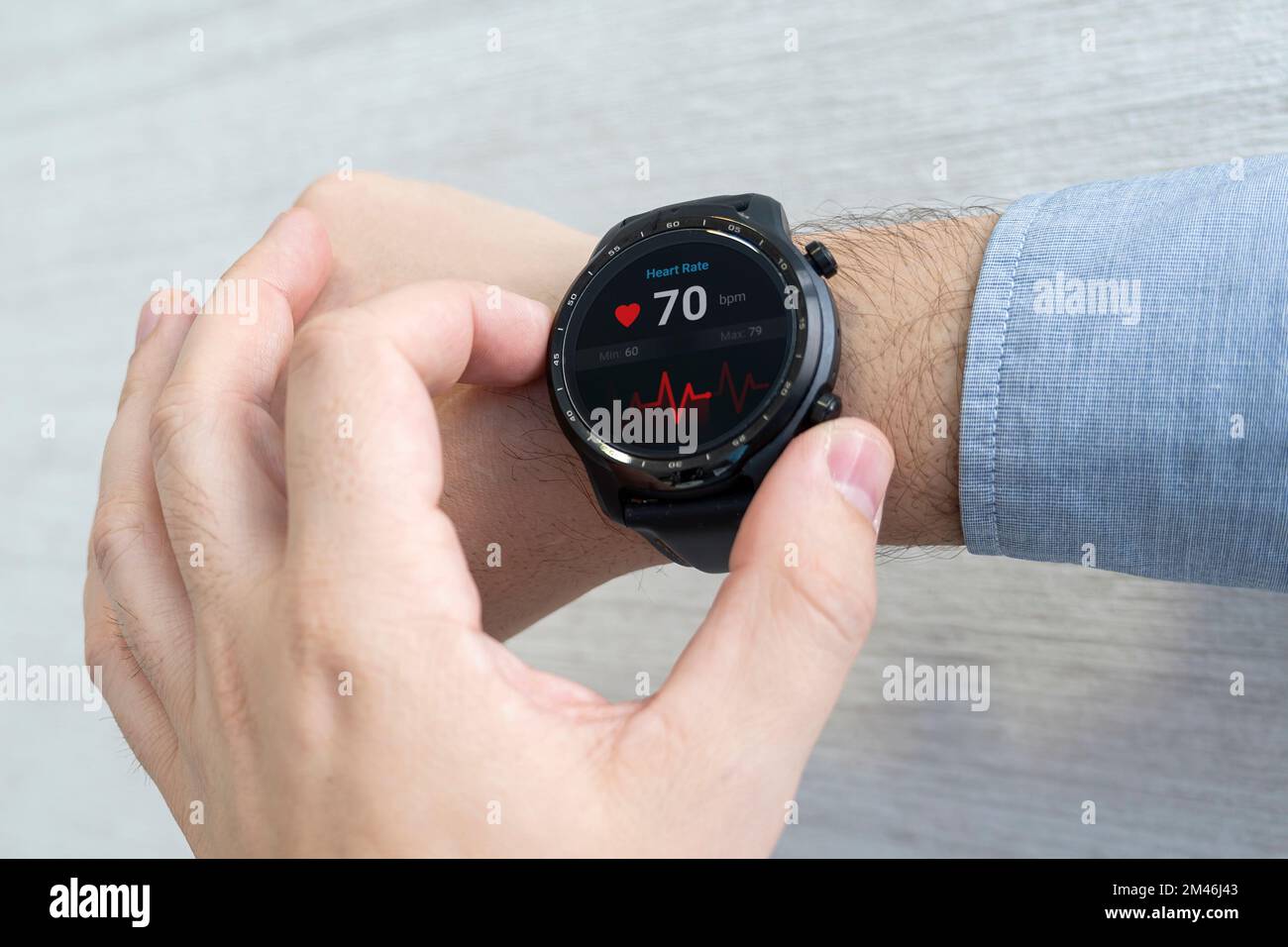 Smart Watch überprüft Herzpuls, Handgelenk des Mannes auf weißem Hintergrund. Ein Geschäftsmann überprüft seinen Puls mit einer Uhr. Stockfoto