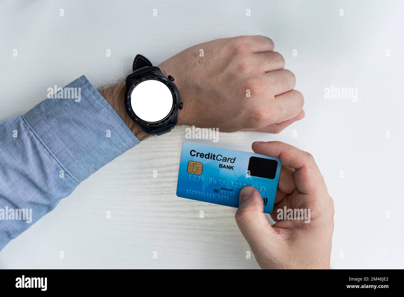 Business, Technologie, Cash Free und Internet People Konzept - Nahaufnahme der männlichen Hände mit Smartwatch und Kreditkarte im Büro. Zeit zum Einkaufen. Leer Stockfoto