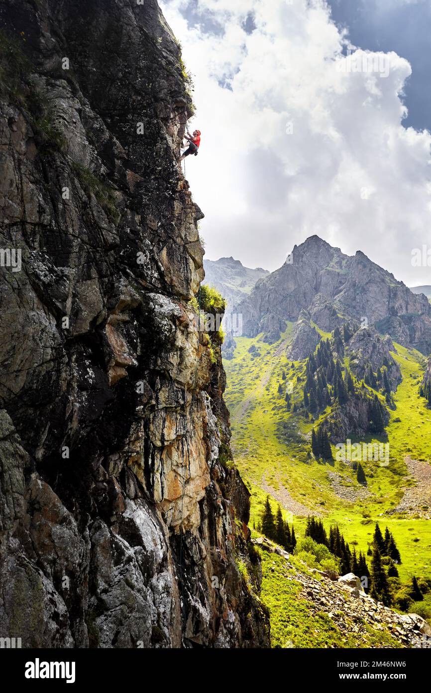 Fit starken Mann Athlet in Silhouette Klettern an der hohen vertikalen Wand an den Bergen Tyan Shan in Kasachstan Stockfoto