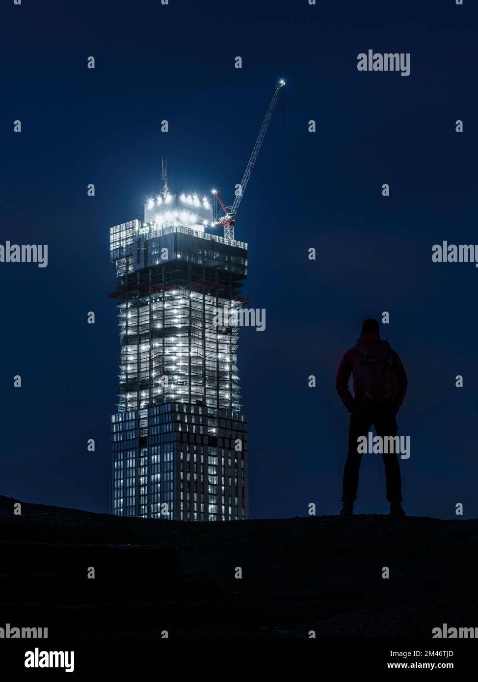 Niedriger Blickwinkel einer Person, die auf das beleuchtete Gebäude blickt Stockfoto