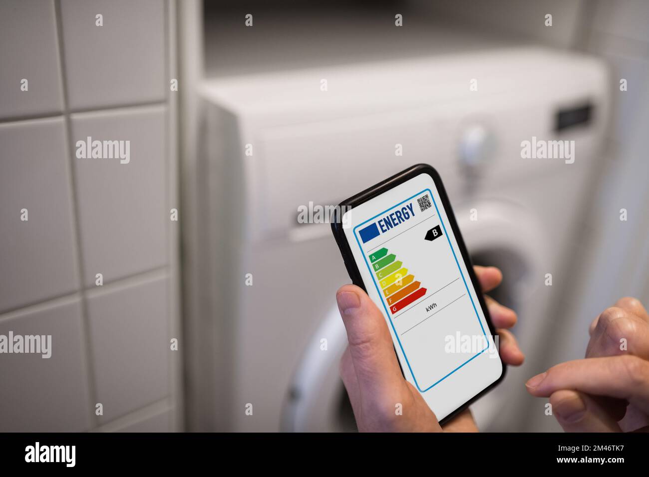 Person, die die Energieetiketten am Telefon überprüft Stockfoto