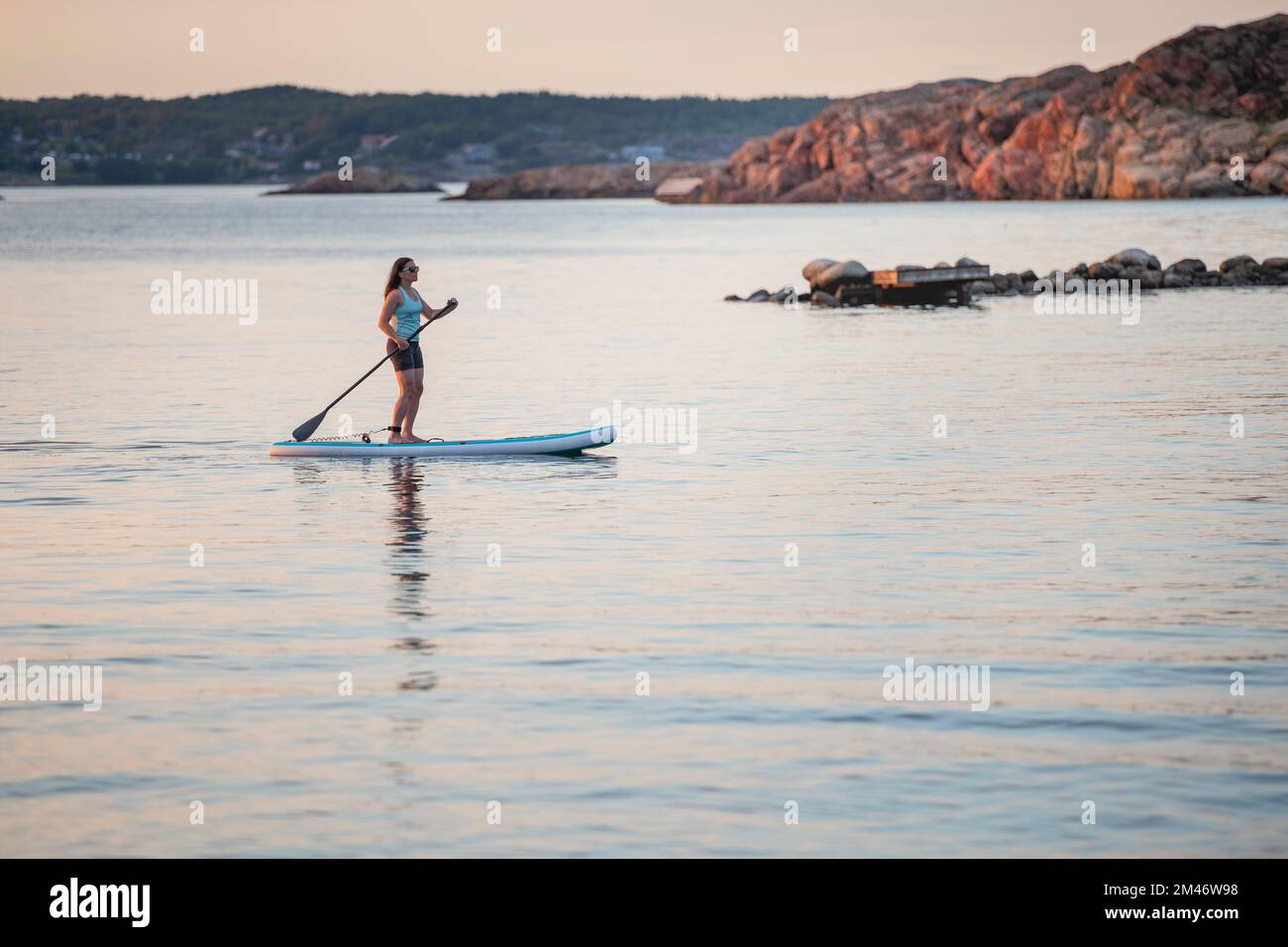 Eine Frau paddelt auf See Stockfoto
