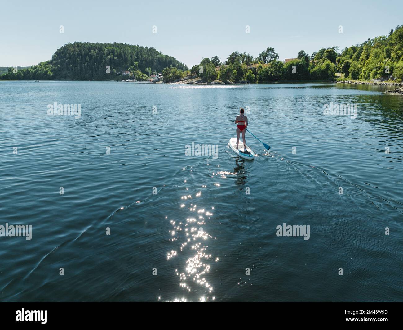 Eine Frau paddelt auf See Stockfoto
