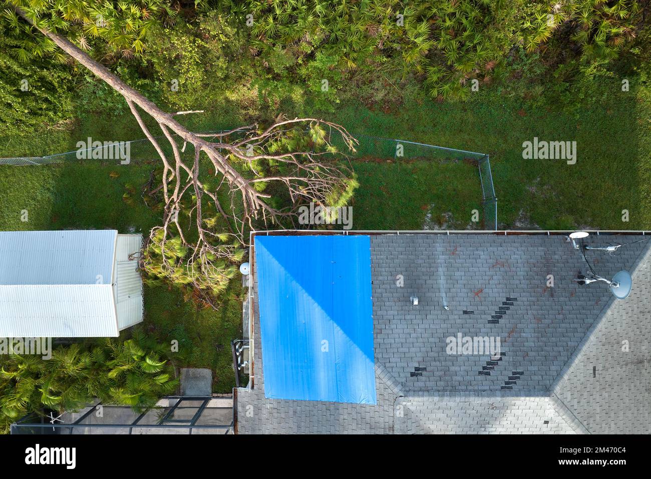 Luftaufnahme des beschädigten Hausdachs von Hurrikan Ian, das mit einer blauen Schutzplane gegen austretendes Regenwasser bedeckt ist, bis die Asphaltschindeln ersetzt wurden Stockfoto