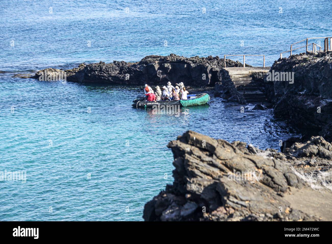 Touristen auf einem Schlauchboot nähern sich einer Insel in den Galapagos, Ecuador Stockfoto