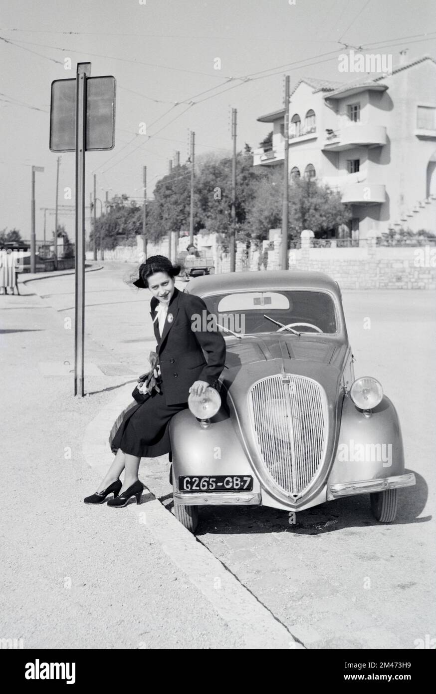 Junge Französin posiert auf dem 5 2-türigen Saloon des Vintage Simca, der zwischen 1836 und 1948 in Nanterre Frankreich hergestellt wurde. Das französisch-italienische Auto war identisch mit dem Fiat 500 Topolina. 1950 in Toulon fotografiert Stockfoto
