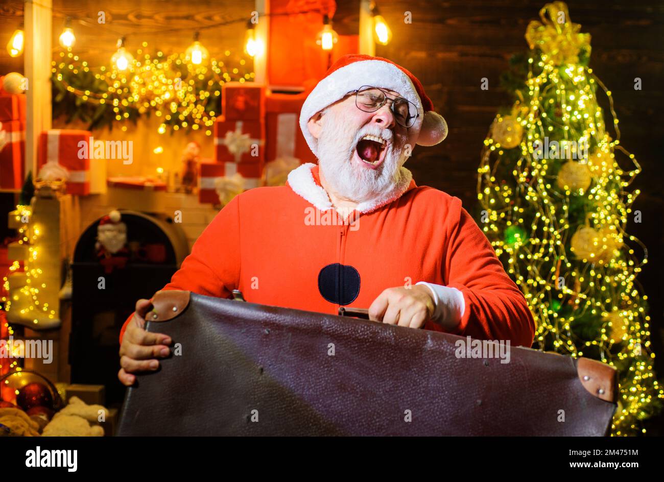 Weihnachtsmann mit Koffer. Neujahrsreisen. Weihnachtsferien. Weihnachtsmann mit Gepäck auf der Reise. Stockfoto