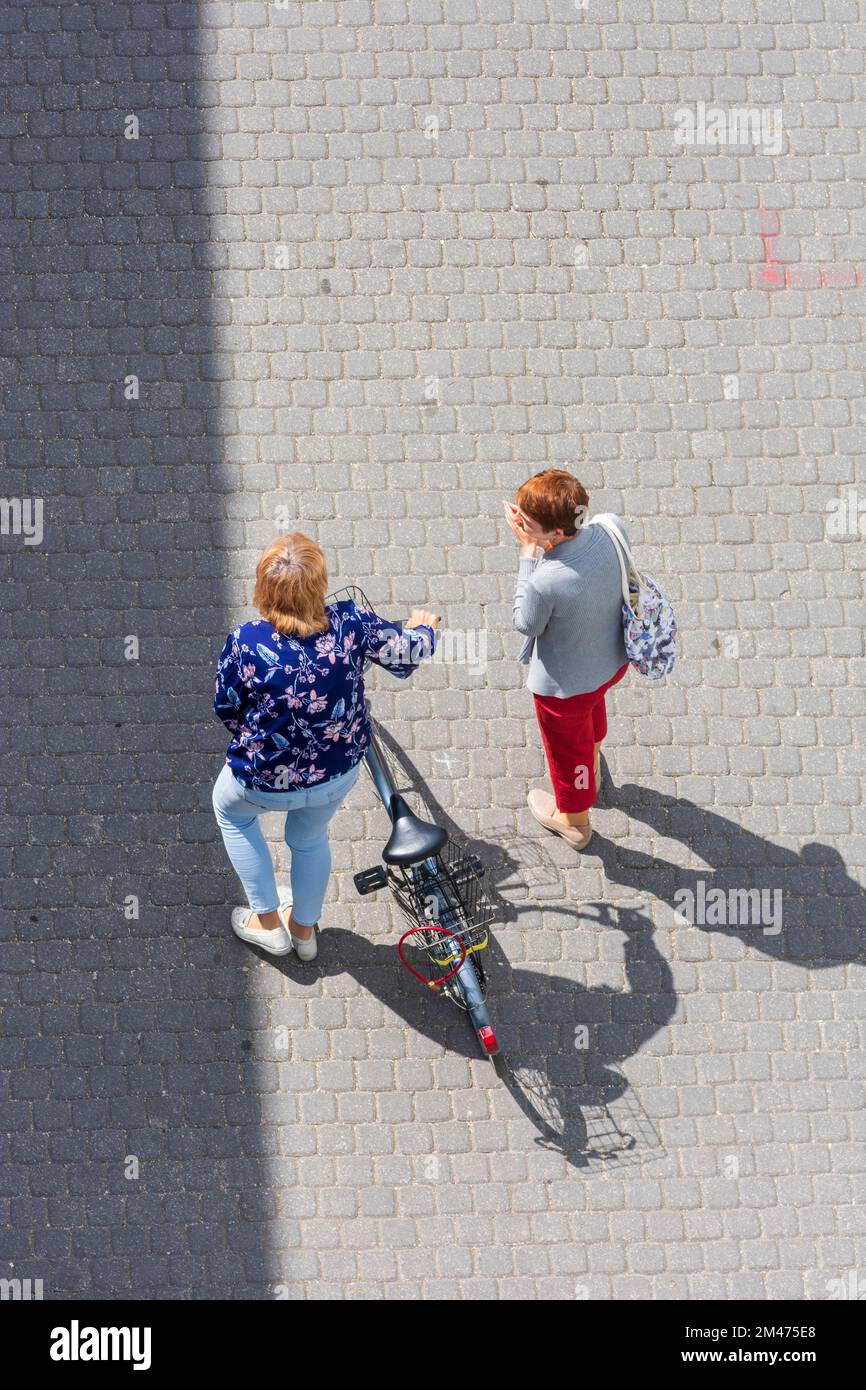 Trencin (Trentschin): Personen, die sprechen, 2 Frauen, mit Fahrrad, von oben in , Slowakei Stockfoto