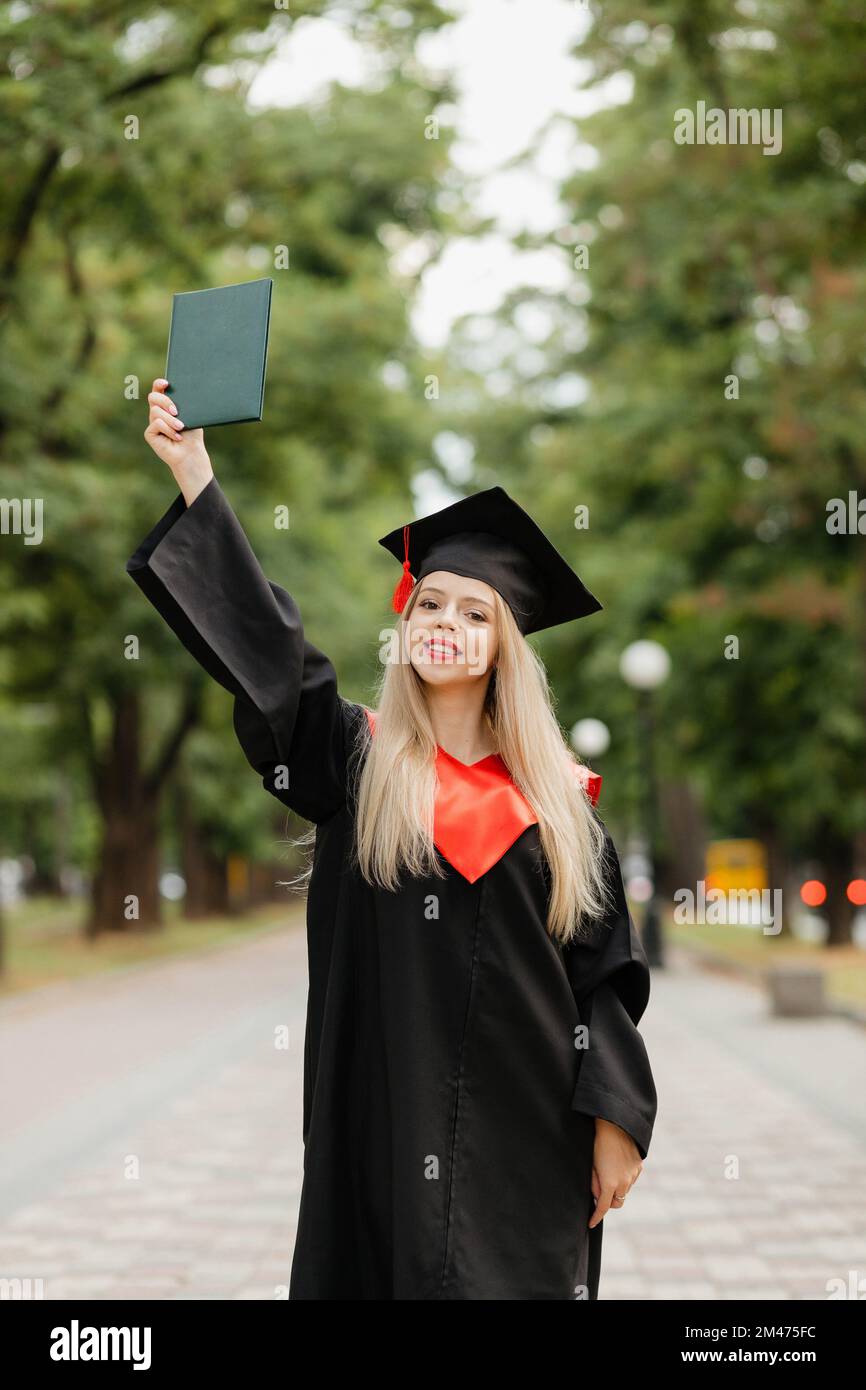 Ein Graduiertenmädchen hält ein Diplom in der Hand Stockfoto