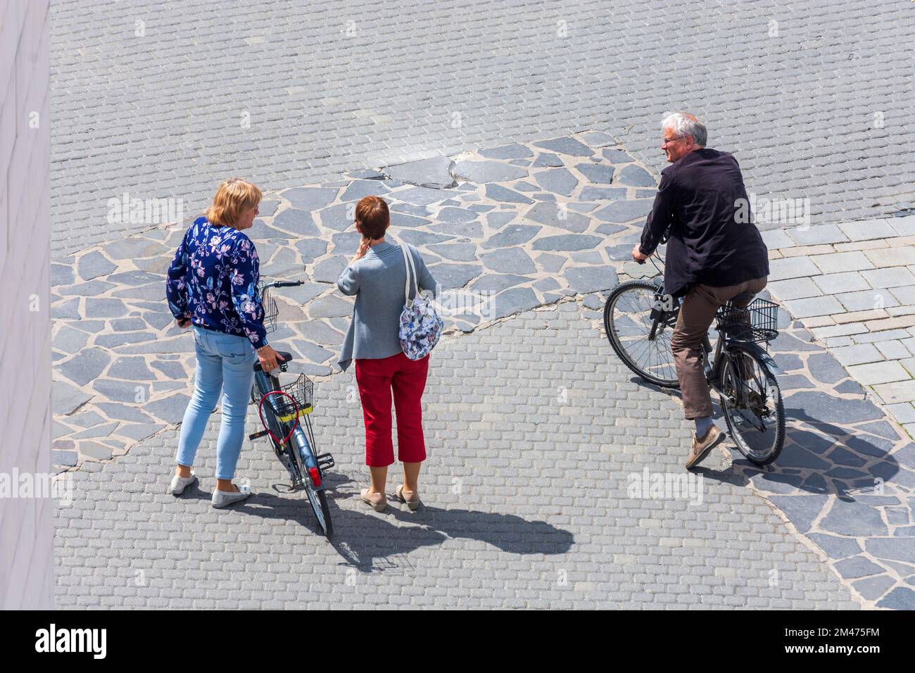 Trencin (Trentschin): Personen, die sprechen, 2 Frauen, 1 Mann, mit Fahrrad in , Slowakei Stockfoto