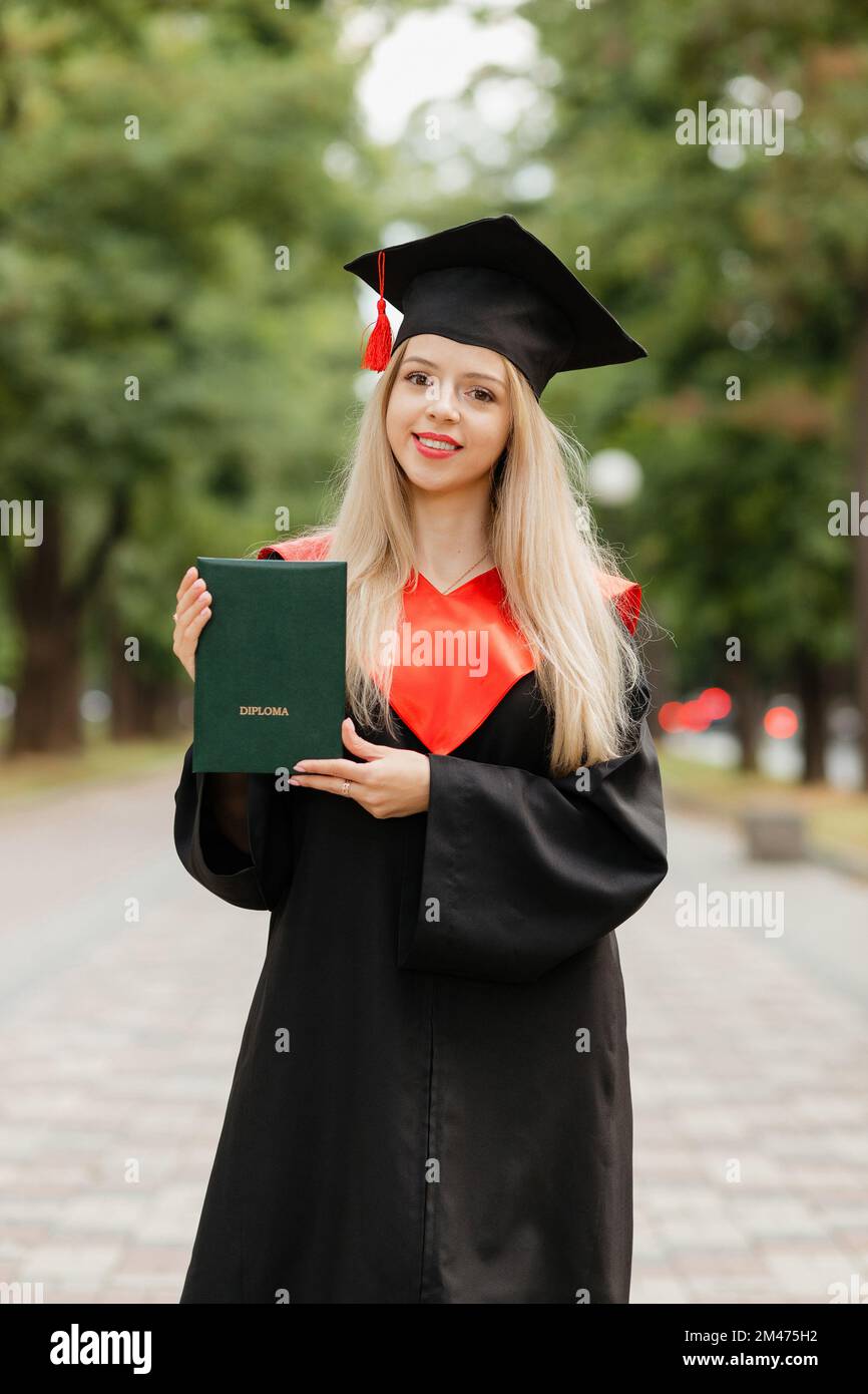 Ein Graduiertenmädchen hält ein Diplom in der Hand Stockfoto
