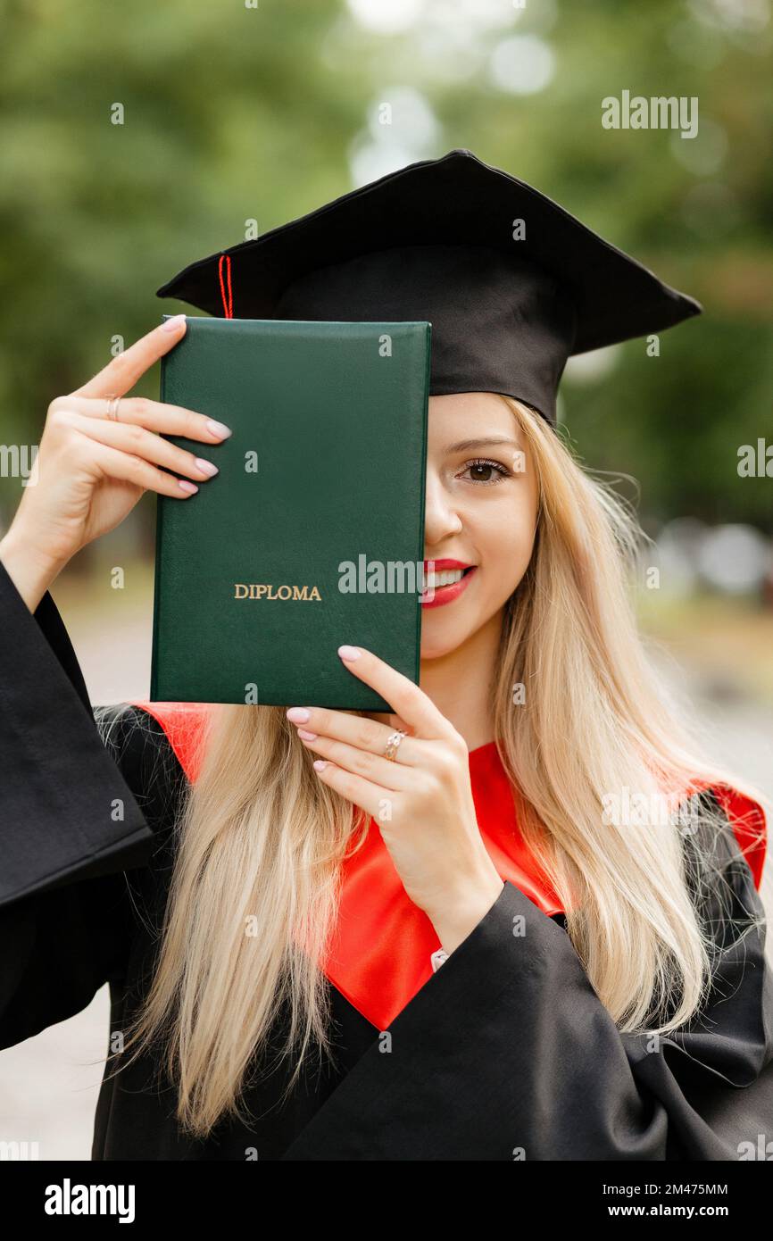Ein Graduiertenmädchen hält ein Diplom in der Hand Stockfoto