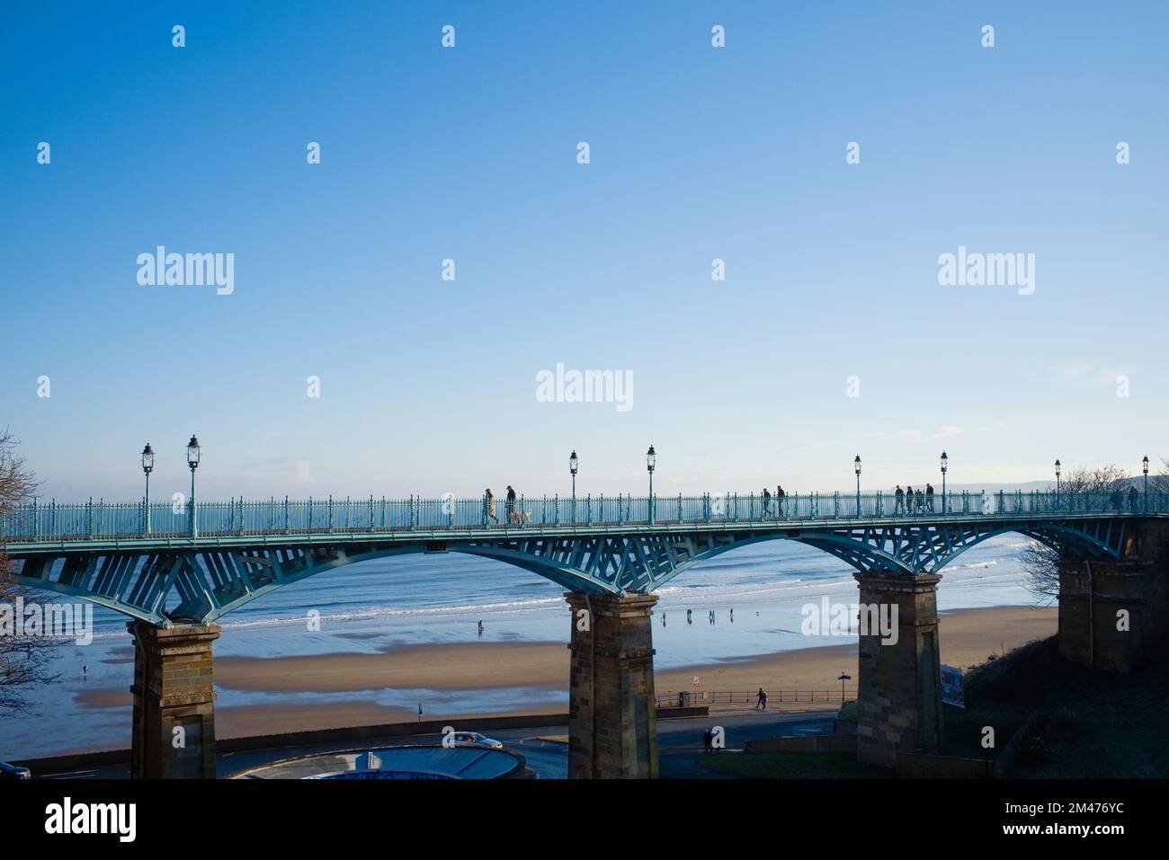 Leute, die an einem Wintermorgen über die Spa Bridge in Scarborough laufen Stockfoto