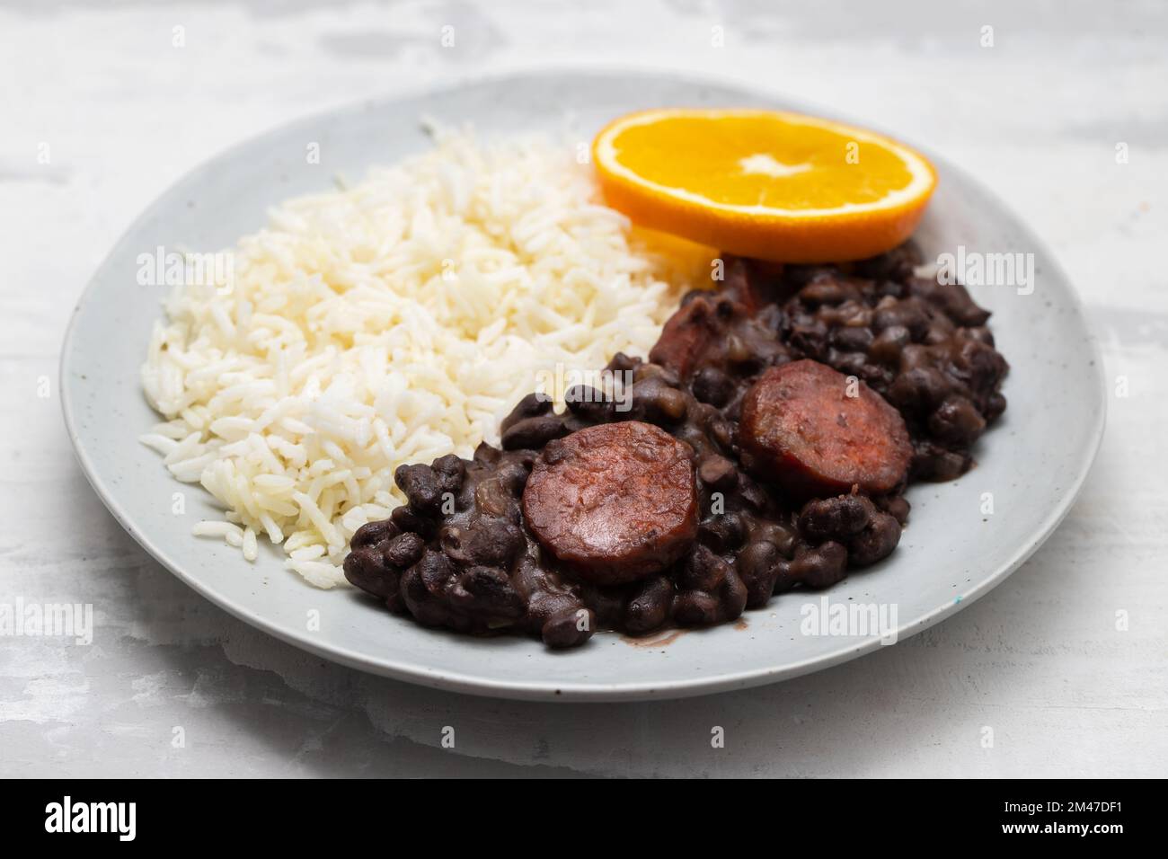 Typisch brasilianische Essensbohnen mit Würstchen und Reis Feijoada auf weißem Gericht Stockfoto