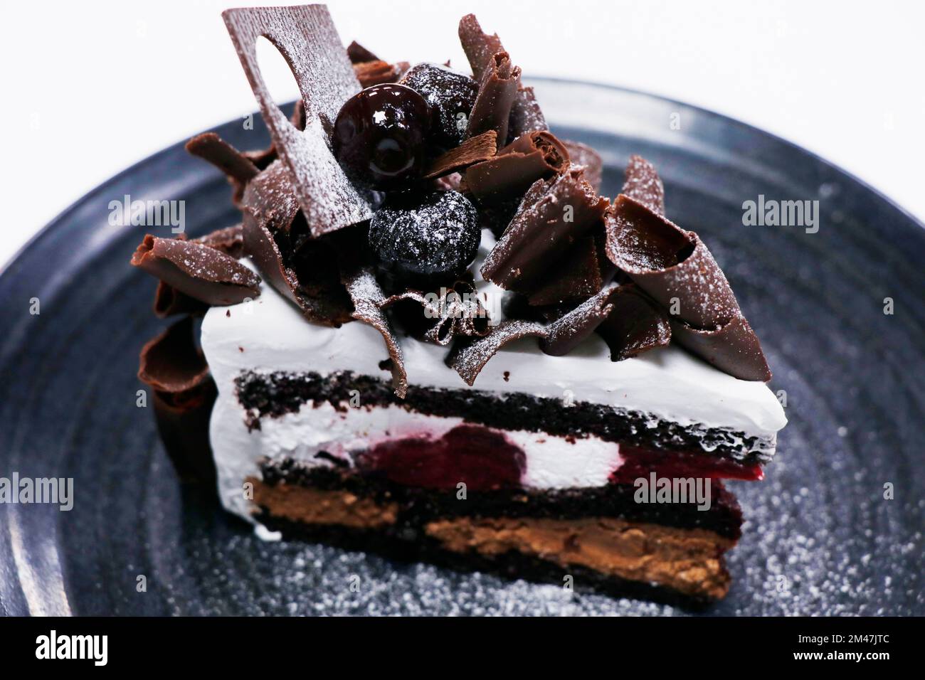 Mehrschichtige Schwarzwälder-Kuchenscheibe mit Kirschcreme und Schokoladenschwamm Stockfoto