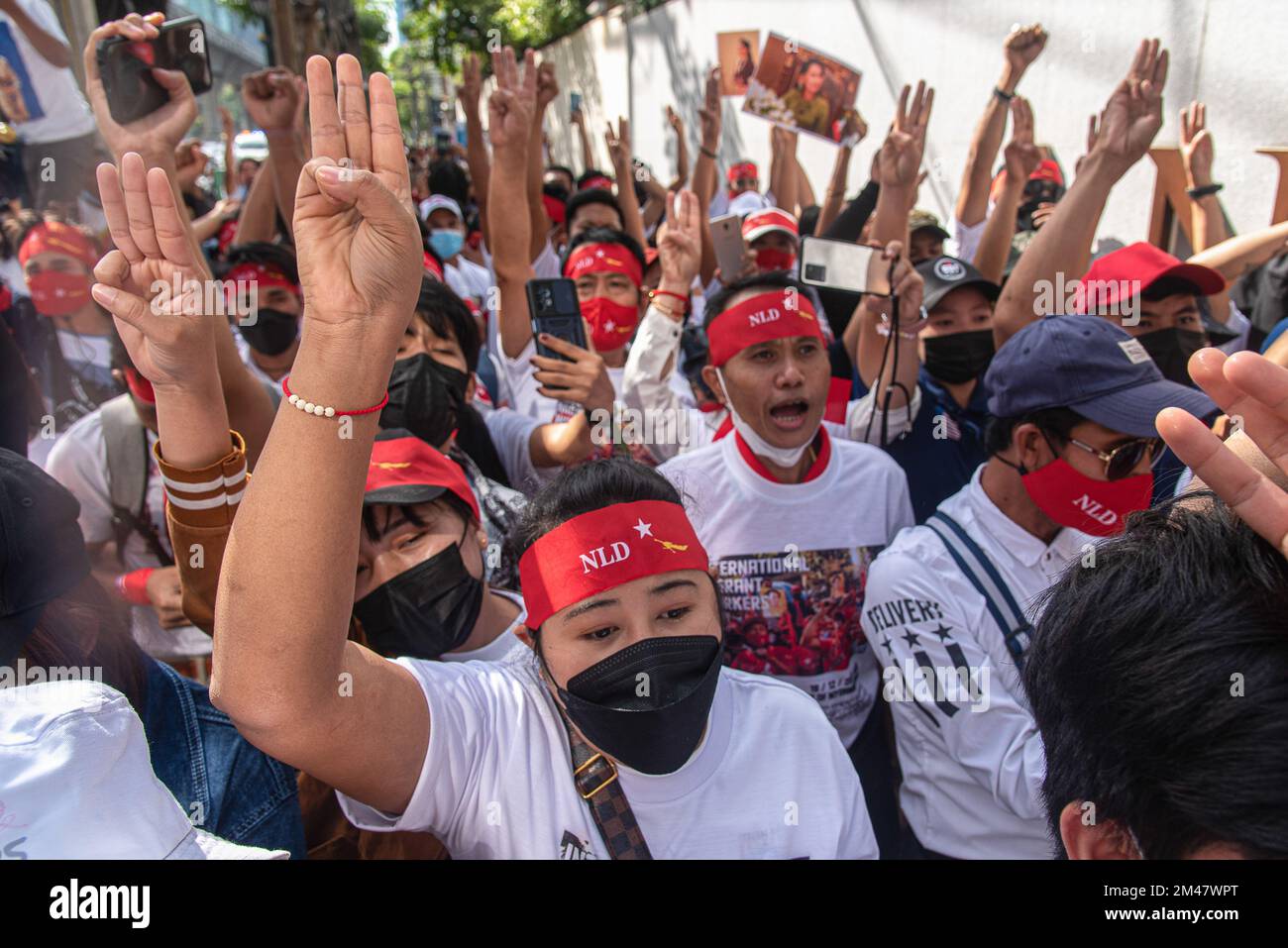 Demonstranten singen Slogans, während sie während der Demonstration drei Finger salutieren. Birmanische Demonstranten versammelten sich vor der Botschaft von Myanmar in Bangkok, um den Internationalen Tag der Migranten zu begehen und gegen die Militärregierung Myanmars zu protestieren. (Foto: Peerapon Boonyakiat / SOPA Images/Sipa USA) Stockfoto