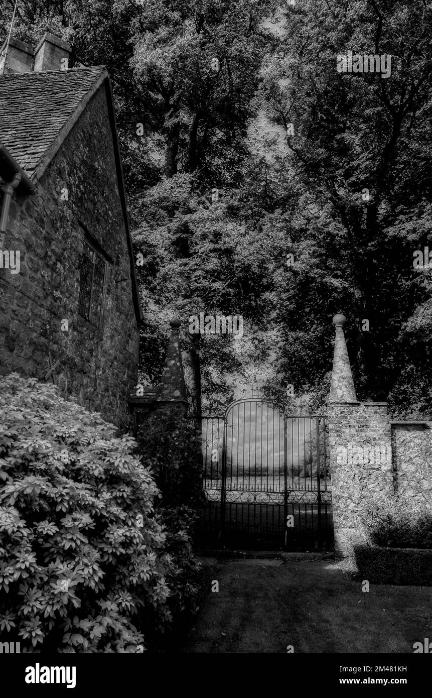 Steinmauer und schmiedeeisernes Tor eines alten Landhauses Stockfoto
