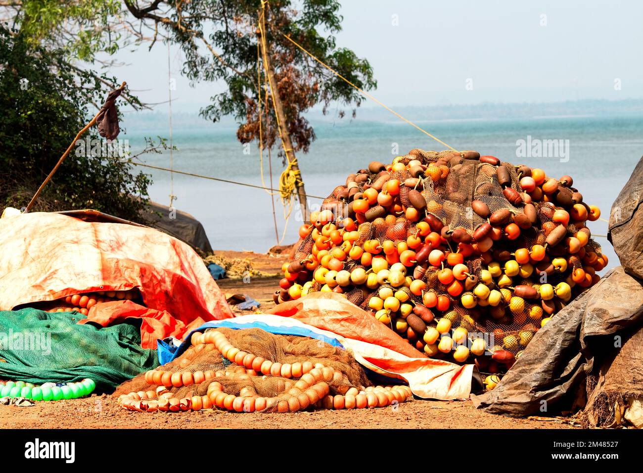 Eine Nahaufnahme von Stapeln rustikaler, farbenfroher Fischernetze am Ufer des Meeres Stockfoto