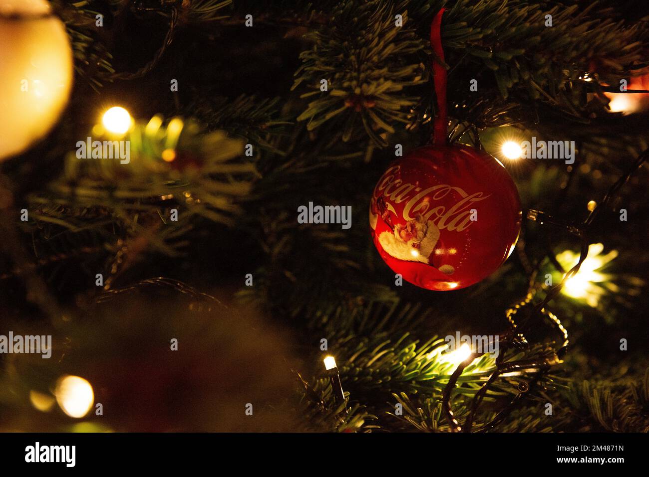 Zagreb, Kroatien - 8. Dezember 2022: Coca-Cola-Dekoration des Weihnachtsbaums mit roten Kugeln im Vintage-Stil, wobei der Weihnachtsmann aus einer Flasche trinkt Stockfoto