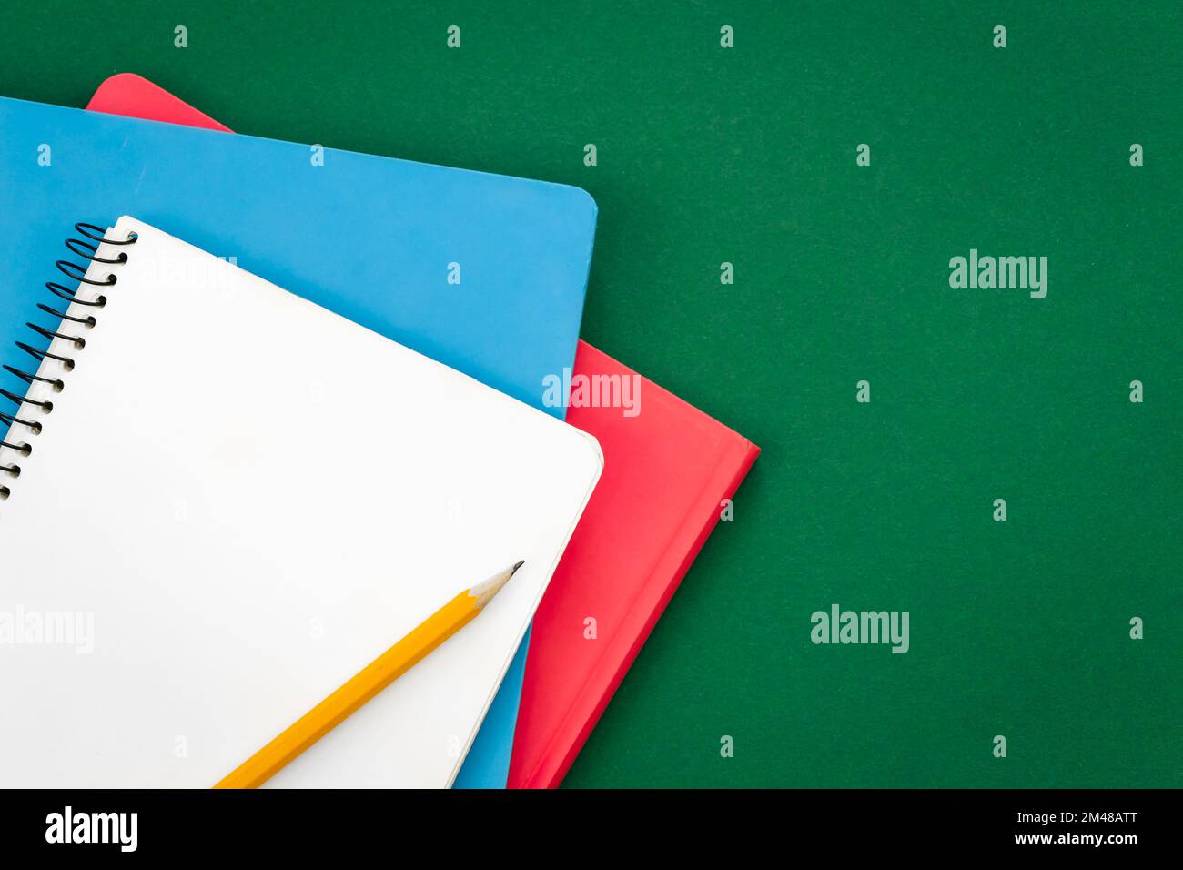 Notizbücher auf grünem Hintergrund, Schulkonzept, flach liegend. Stockfoto