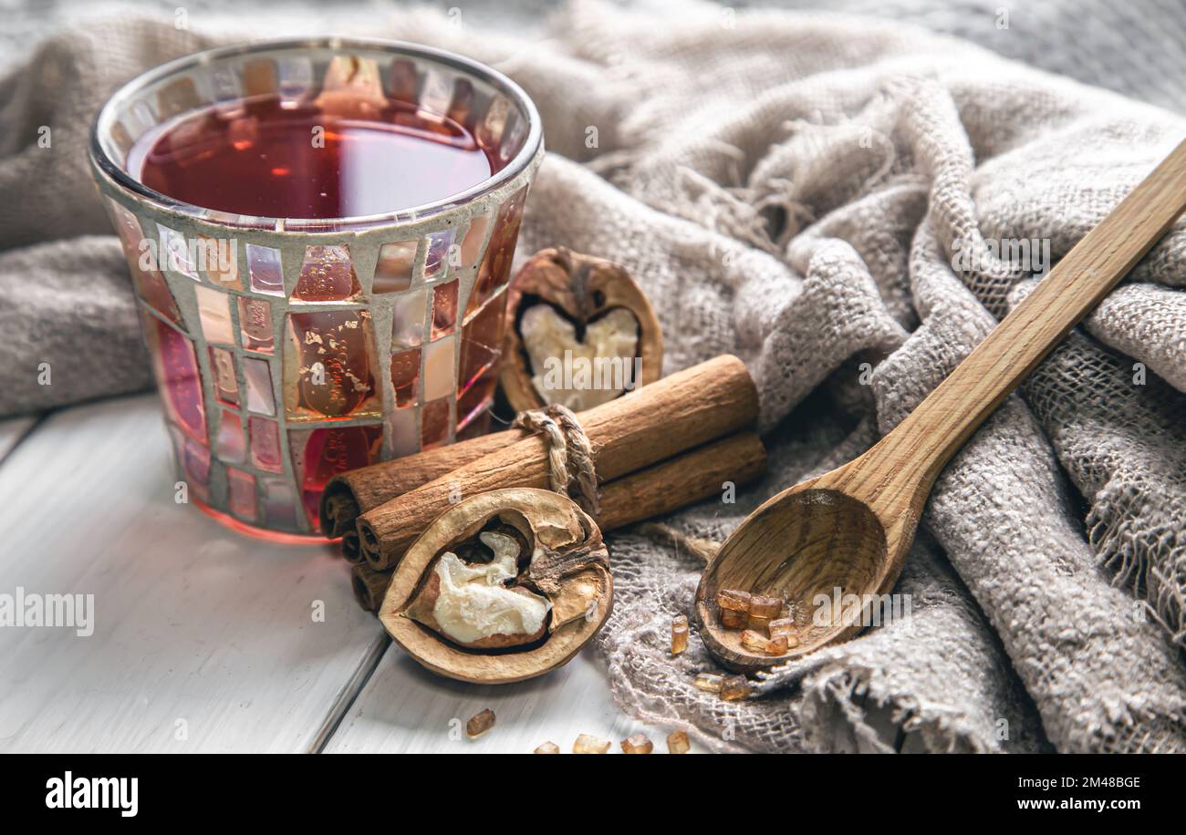 Tasse Tee, Zimtstangen und Walnüsse aus der Nahaufnahme. Stockfoto