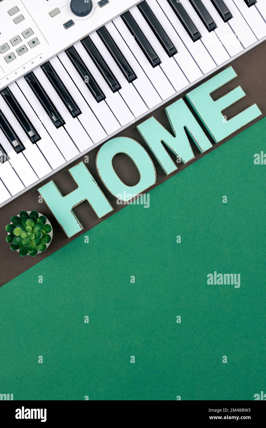 Musikalische Tasten und dekoratives Wort Zuhause auf einem farbigen Hintergrund. Stockfoto