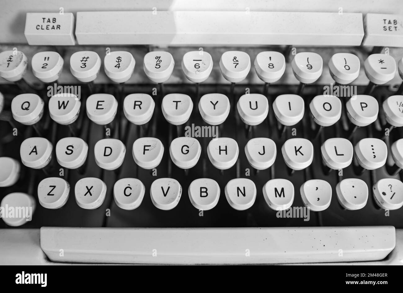 Schreibmaschine. Nahaufnahme der weißen Schreibmaschinentasten. Ein Schuss Schlüssel auf einer antiken Schreibmaschine. Niemand, selektiver Fokus, verschwommen Stockfoto