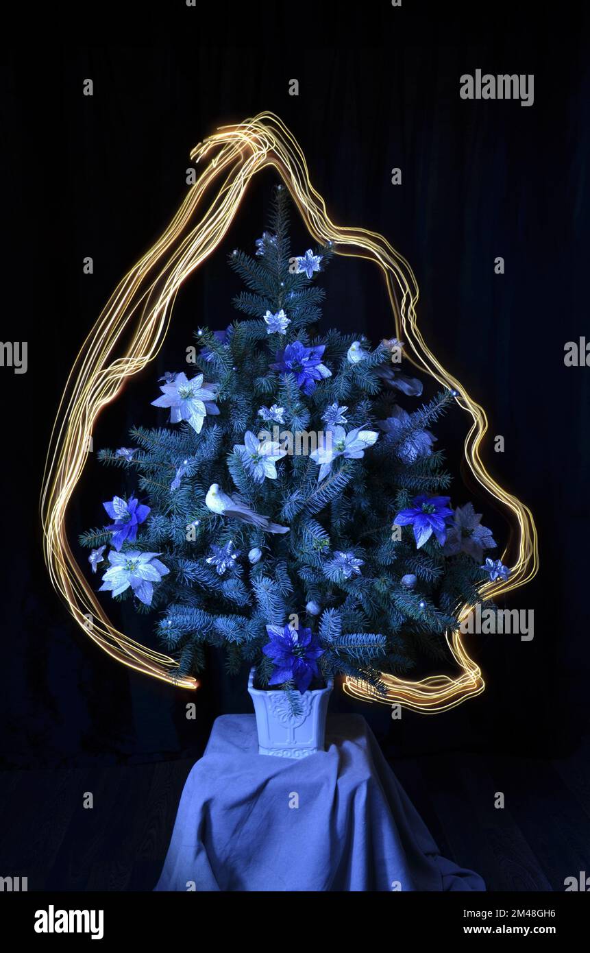 Weihnachtsbaum mit Dekorationen. Licht um den Baum. Bestandsbild. Stockfoto