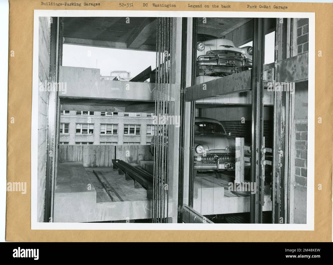 Park O-Mat Garage auf K Street, NW, zwischen 14.. Und 15.. Straße. Originalunterschrift: Park O-Mat Garage in K Street, N.W., zwischen 14.. Und 15.. Straße. Erstes automatisches Parkhaus in Washington, D.C. (und bis zu diesem Datum nur eines, 2. April 1952). Autos werden vollständig mechanisch geparkt und an die Fahrer zurückgegeben. Siehe: 52-329 bis 52-336. Foto von C. H. Ritter und T. W. Kines. Bundesstaat: Bezirk Columbia. Ort: Washington, D.C. Stockfoto