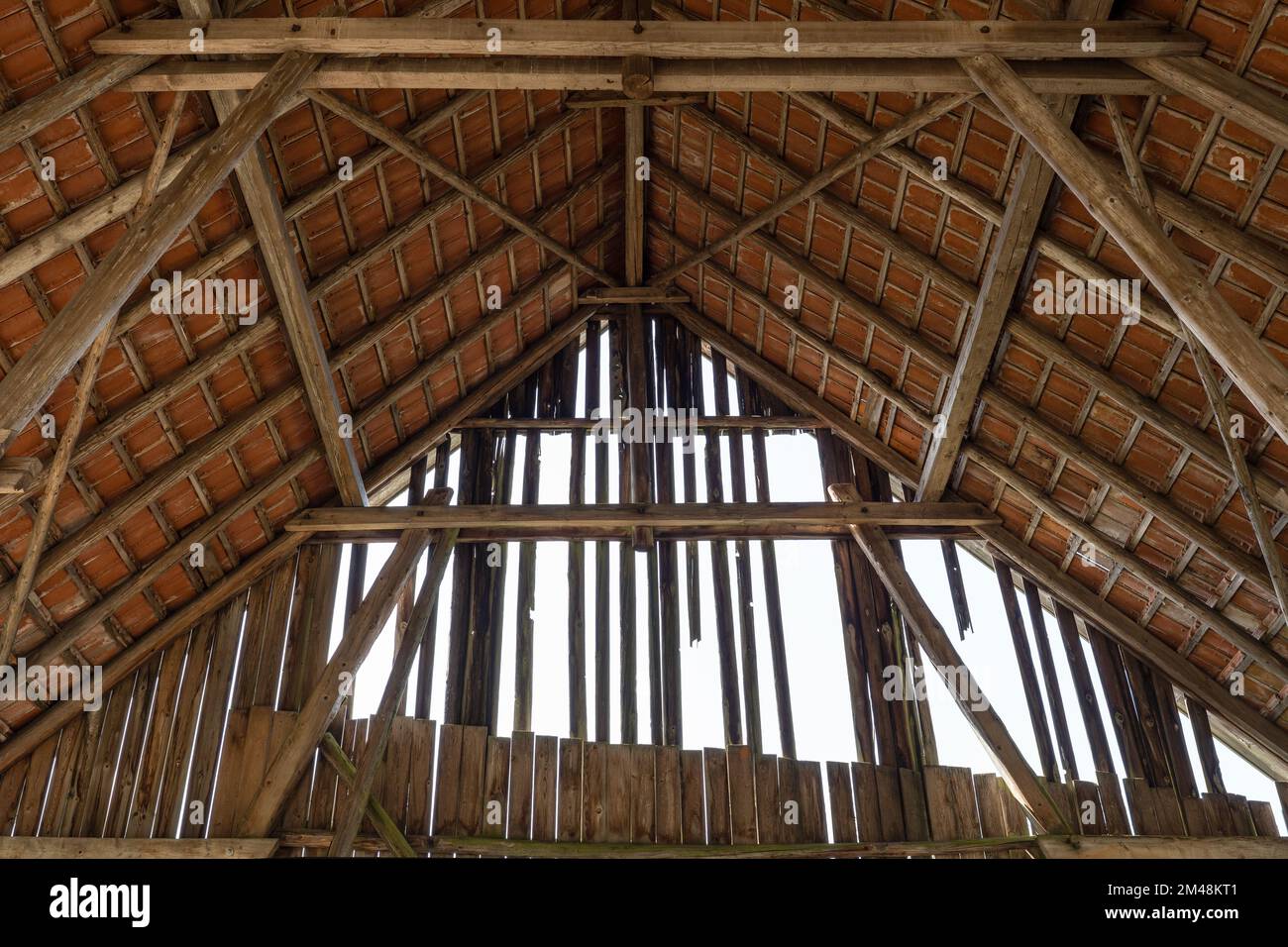 Das Innere einer alten Scheune mit Dachkonstruktion und verfallenem Giebel Stockfoto