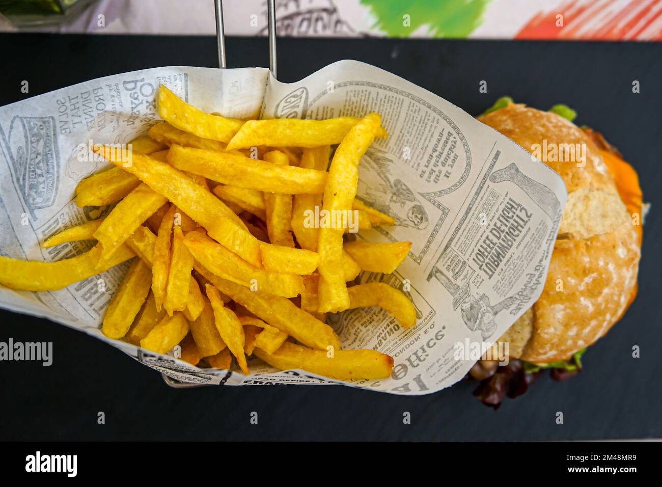 Frittierte Kartoffeln in Zeitungsdruckpapier Stockfoto