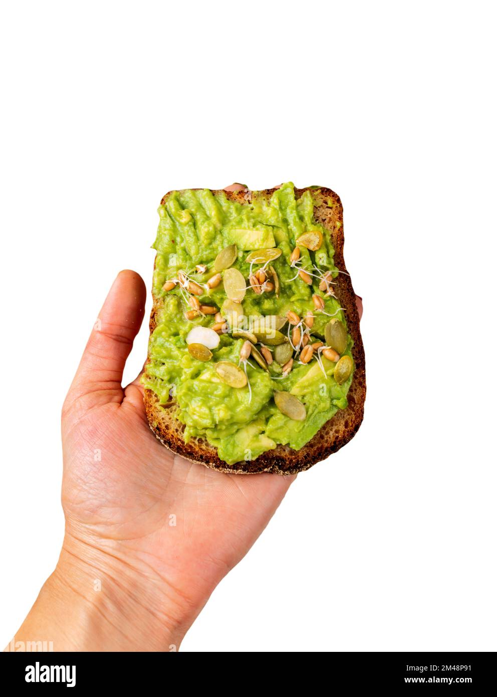 Avocado-Guacamole-Sandwich bei einer weiblichen Hand mit Kürbiskernen und isolierten Weizenkeimlingen Stockfoto